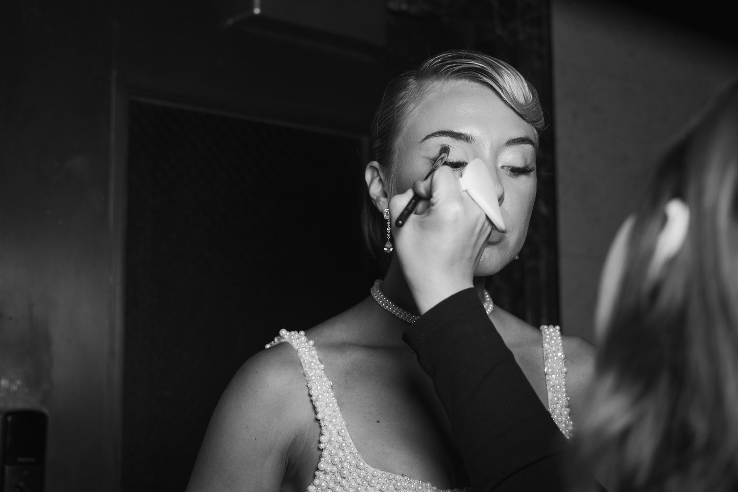 Monochrome close-up of sparkling jewelry and elegant evening wear details.