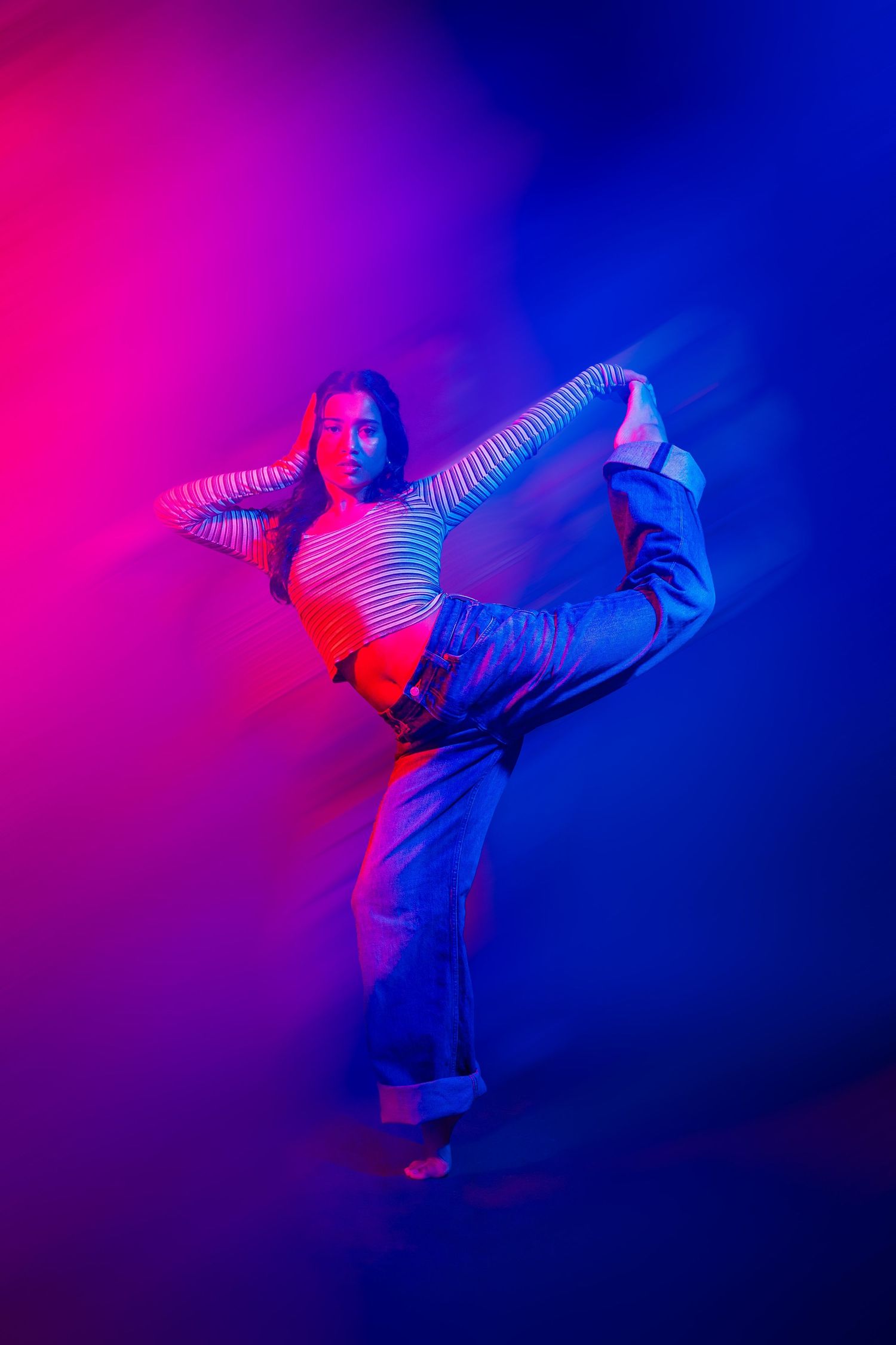 Dynamic dance movements captured in vibrant pink and blue neon lighting effects.