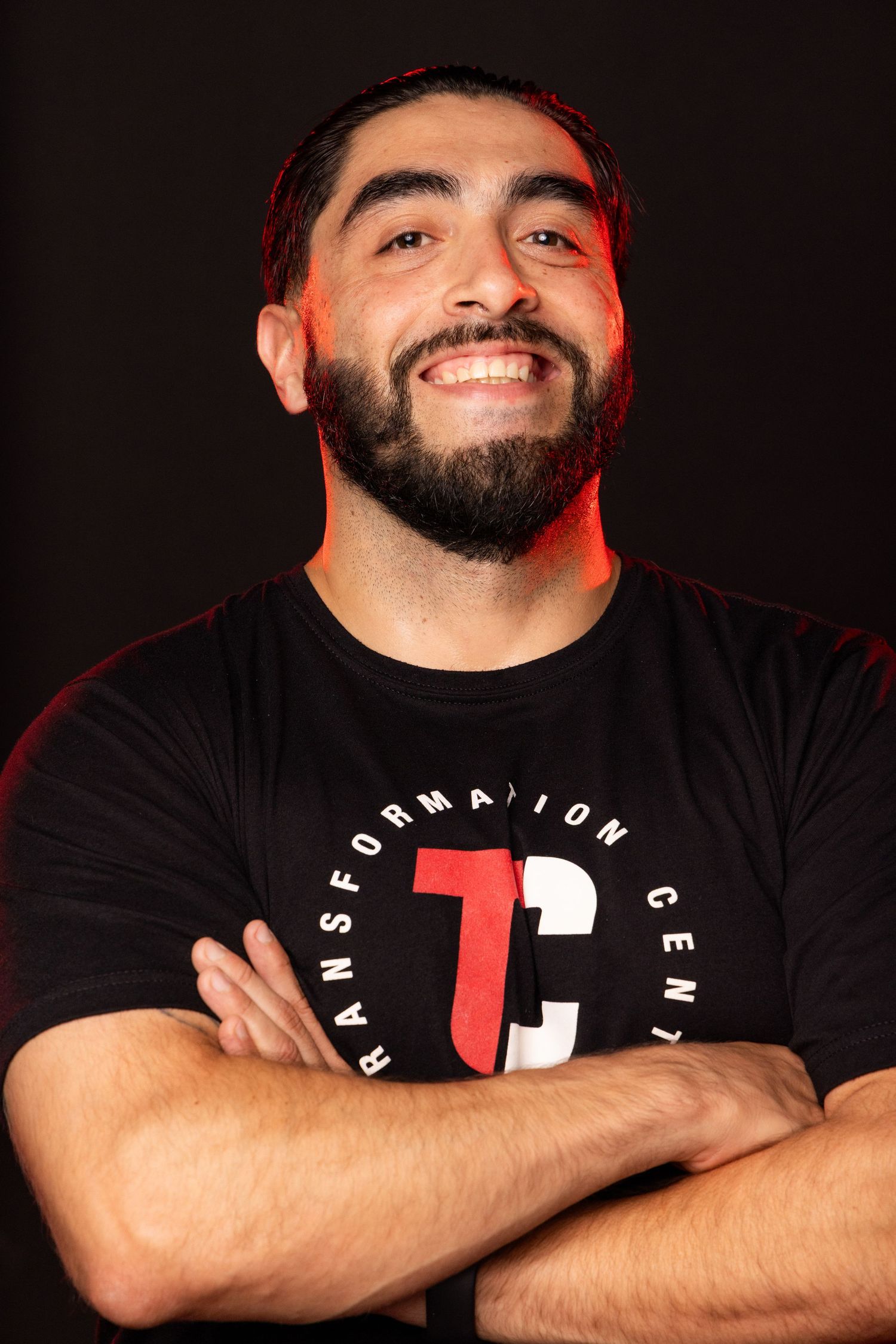 Professional headshots against black background with dramatic red lighting showing bearded man in black t-shirt.