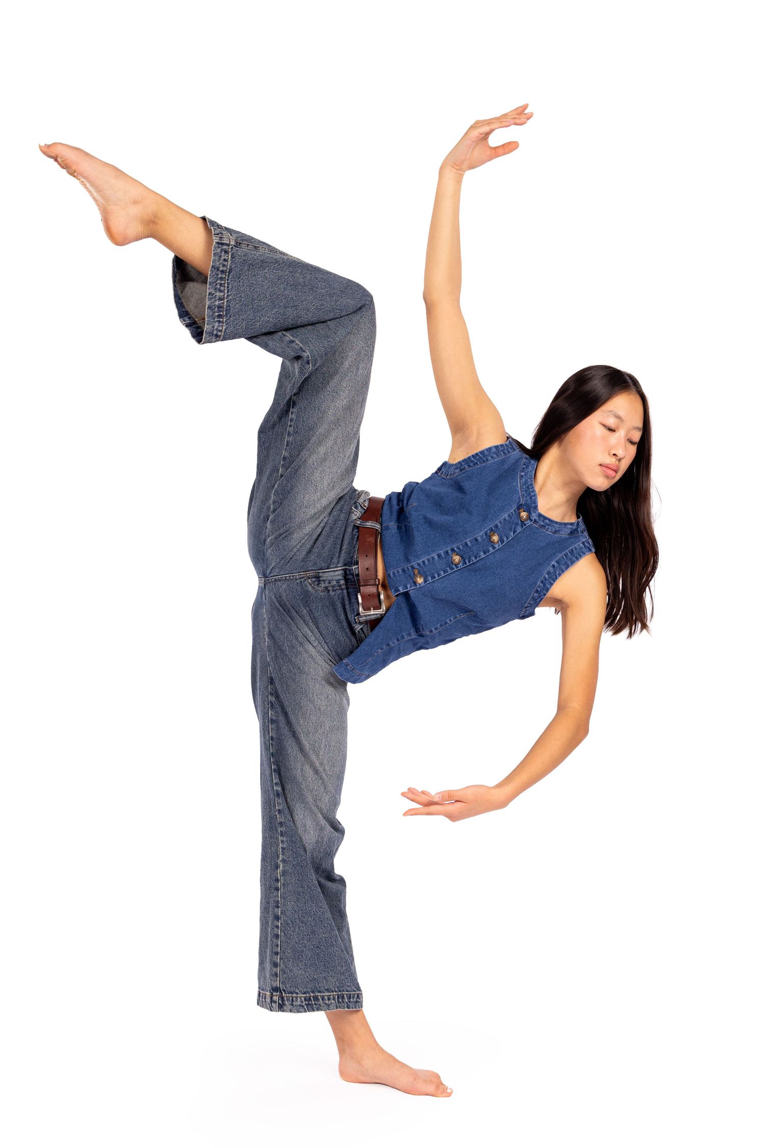 Dancer in denim performs a high kick sequence against white background showing flexibility and control.
