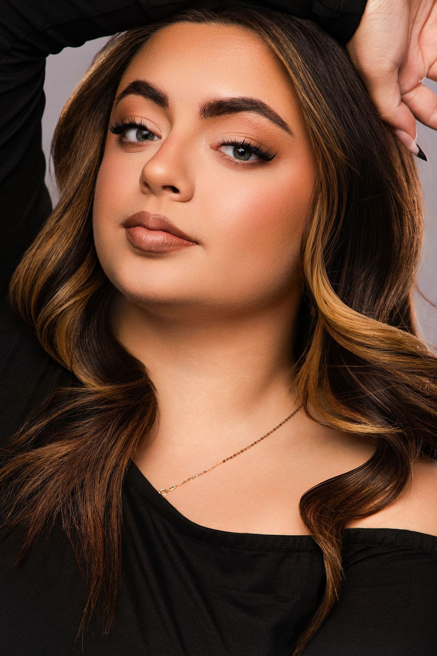 Beauty portrait series showcasing glowing makeup and caramel-highlighted hair against dark background.