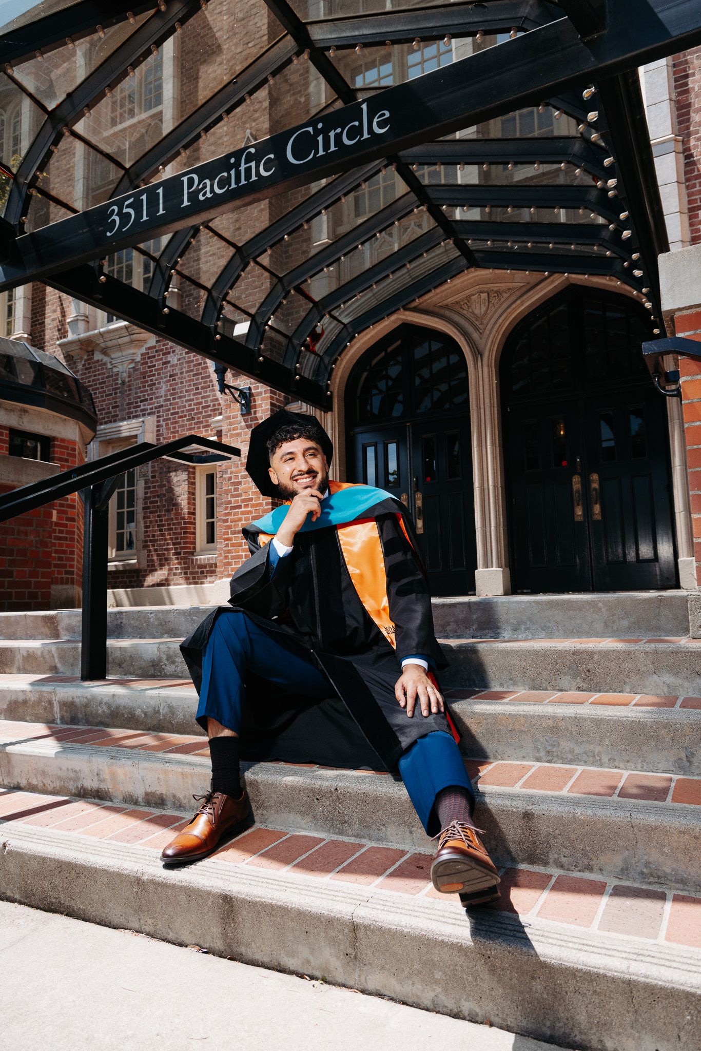 Person in navy shirt and orange sweater sitting on concrete steps outside brick building in sequence of five photos.