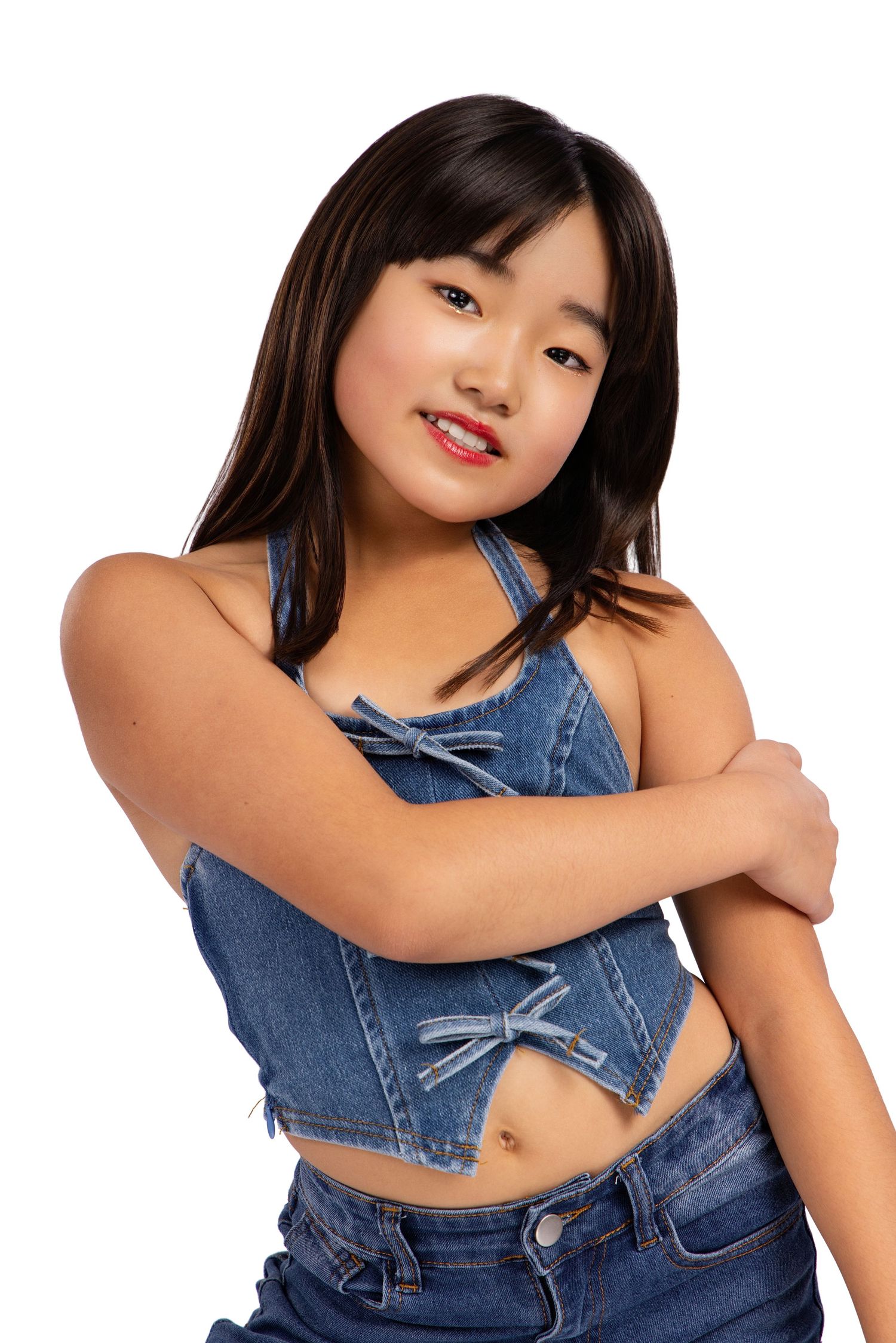 Model wearing denim outfit strikes playful poses in studio photoshoot.
