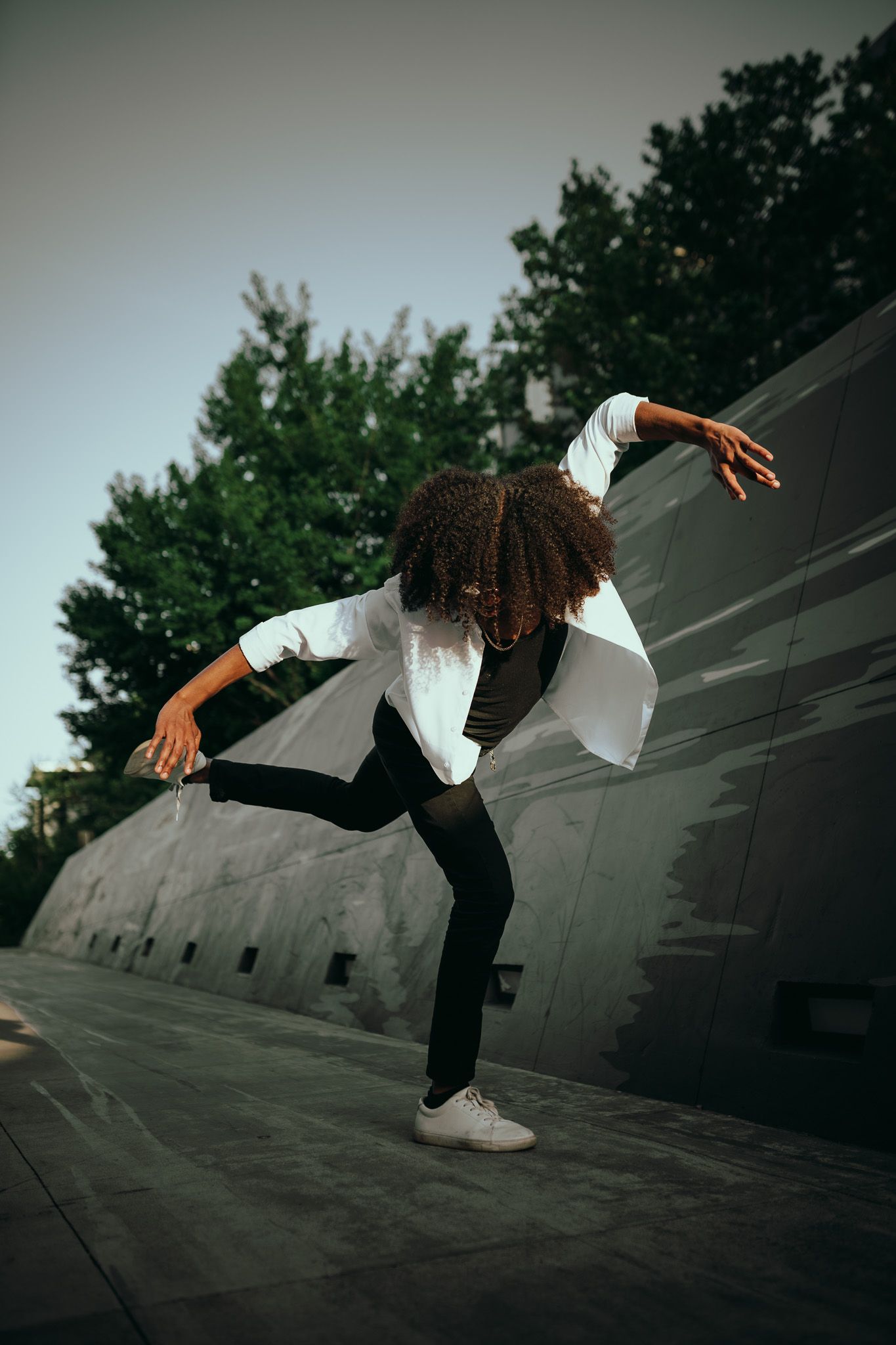 Dynamic dance moves captured in a series of dramatic jumping poses against a concrete wall outdoors.