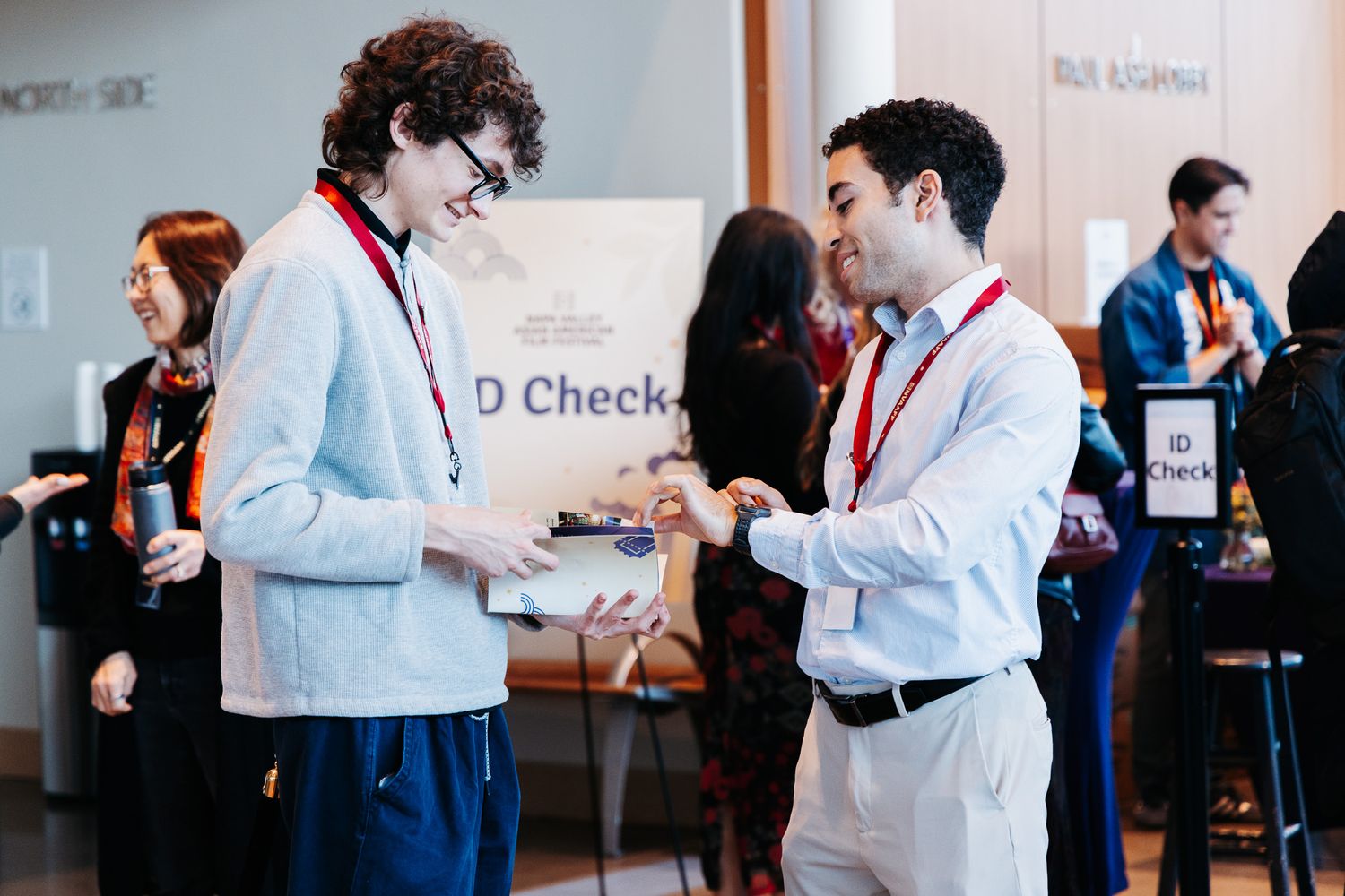 People in professional attire gather at a conference or meeting space.