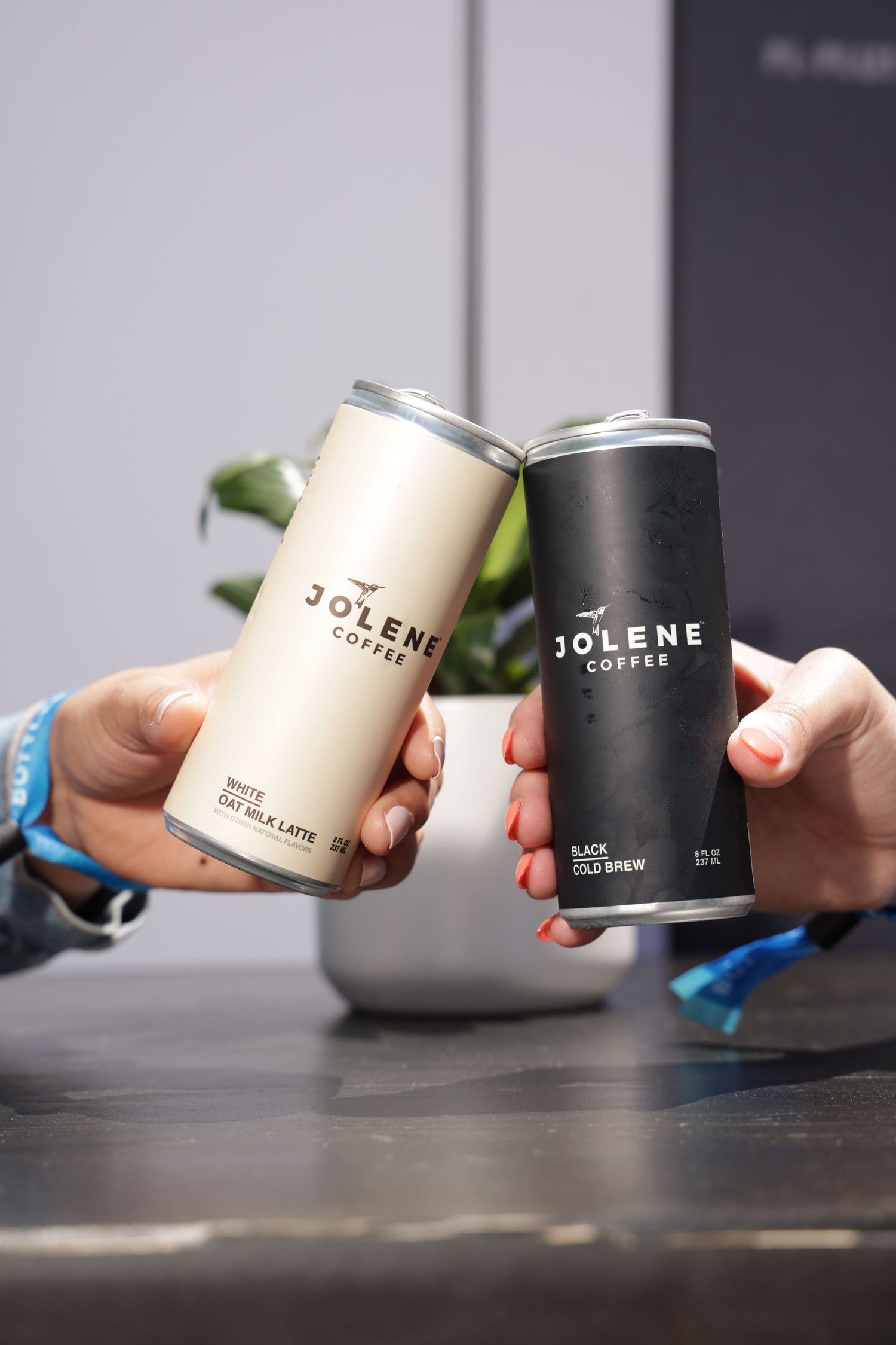 Stop motion sequence showing black and white Jolene branded product containers moving across a dark surface.