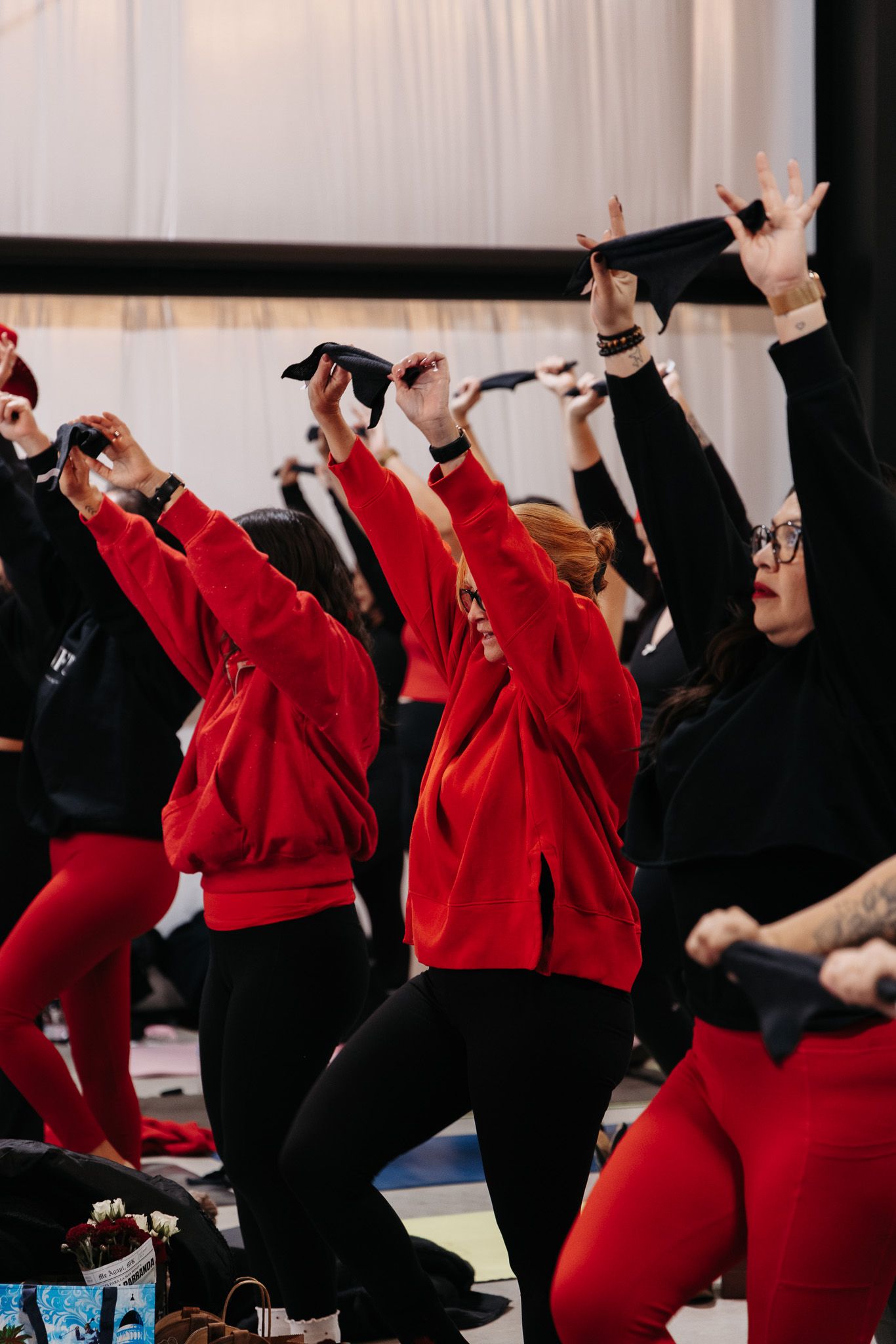 Dancers in red and black outfits performing synchronized movements during a choreographed routine.