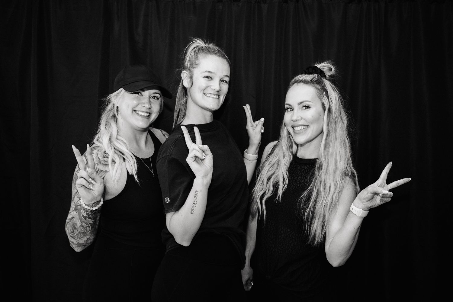A series of candid black and white group photos showing people making peace signs and posing playfully together.