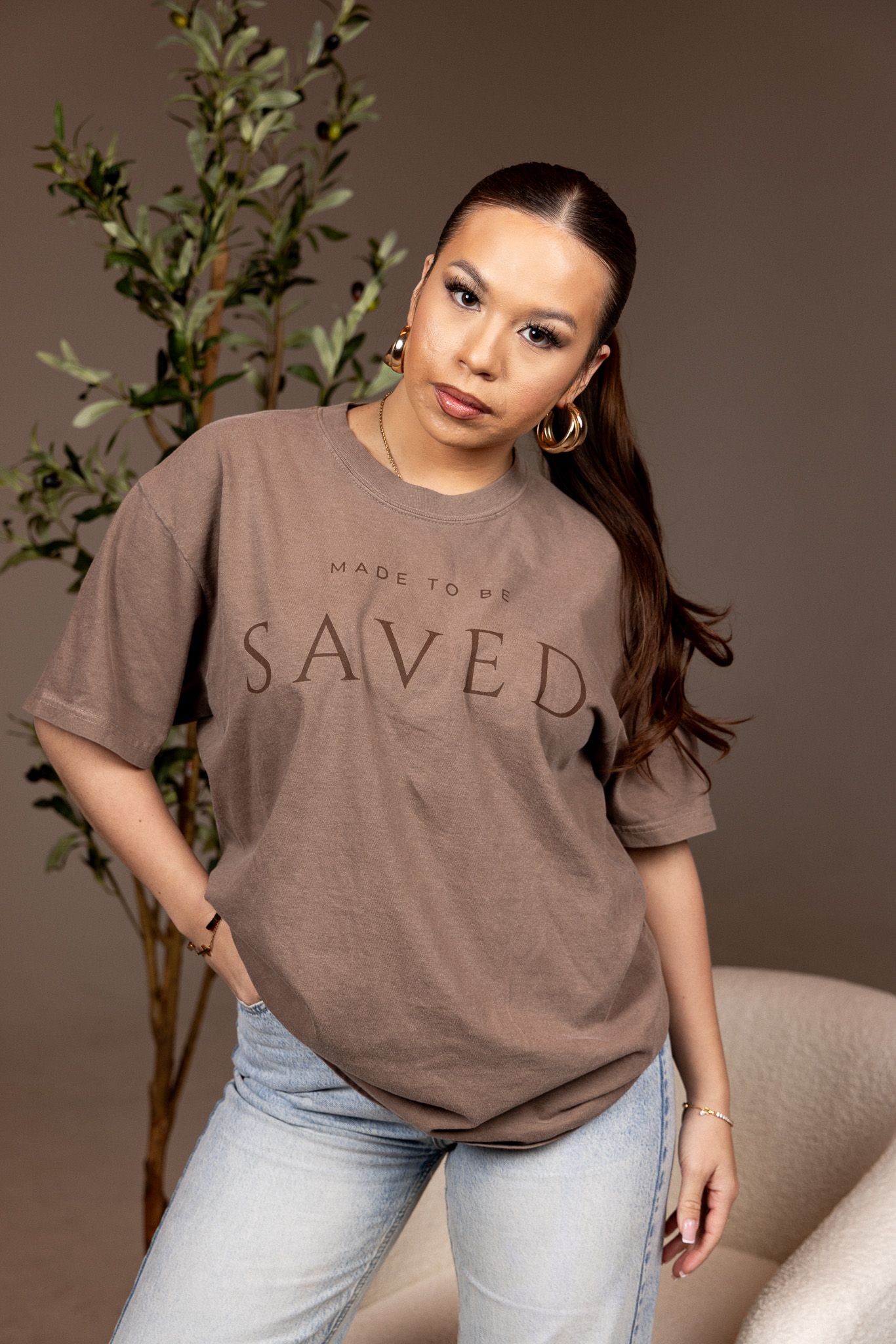 A model poses in a brown t-shirt with 