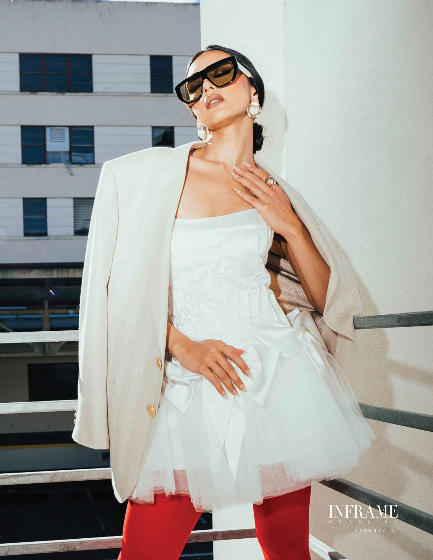 A person wearing a white blazer and red pants poses in multiple fashion shots against a light-colored wall.