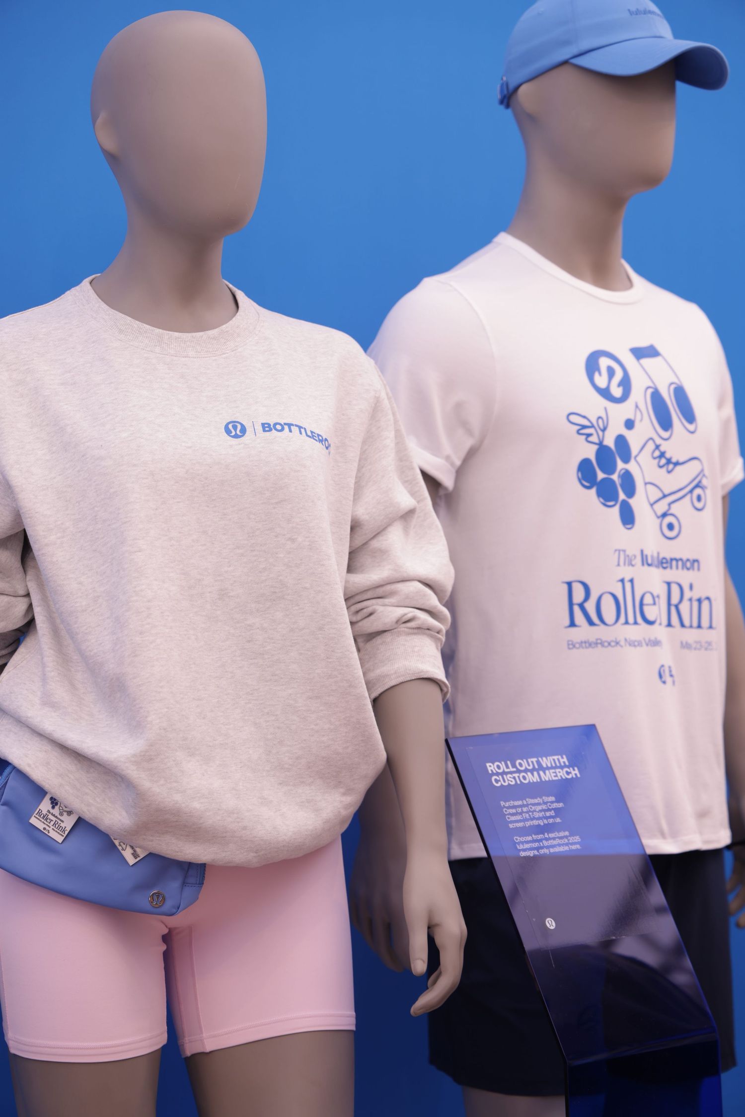 Display of white t-shirts and shorts with blue RolleRun branding on retail mannequins.