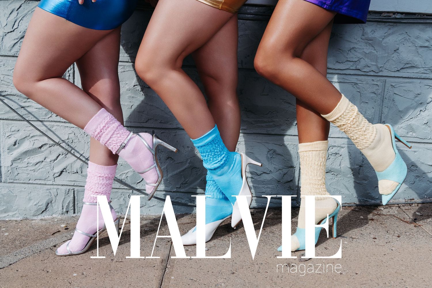 Three women wearing colorful socks and clear heeled boots posing for Malvie Magazine fashion editorial.