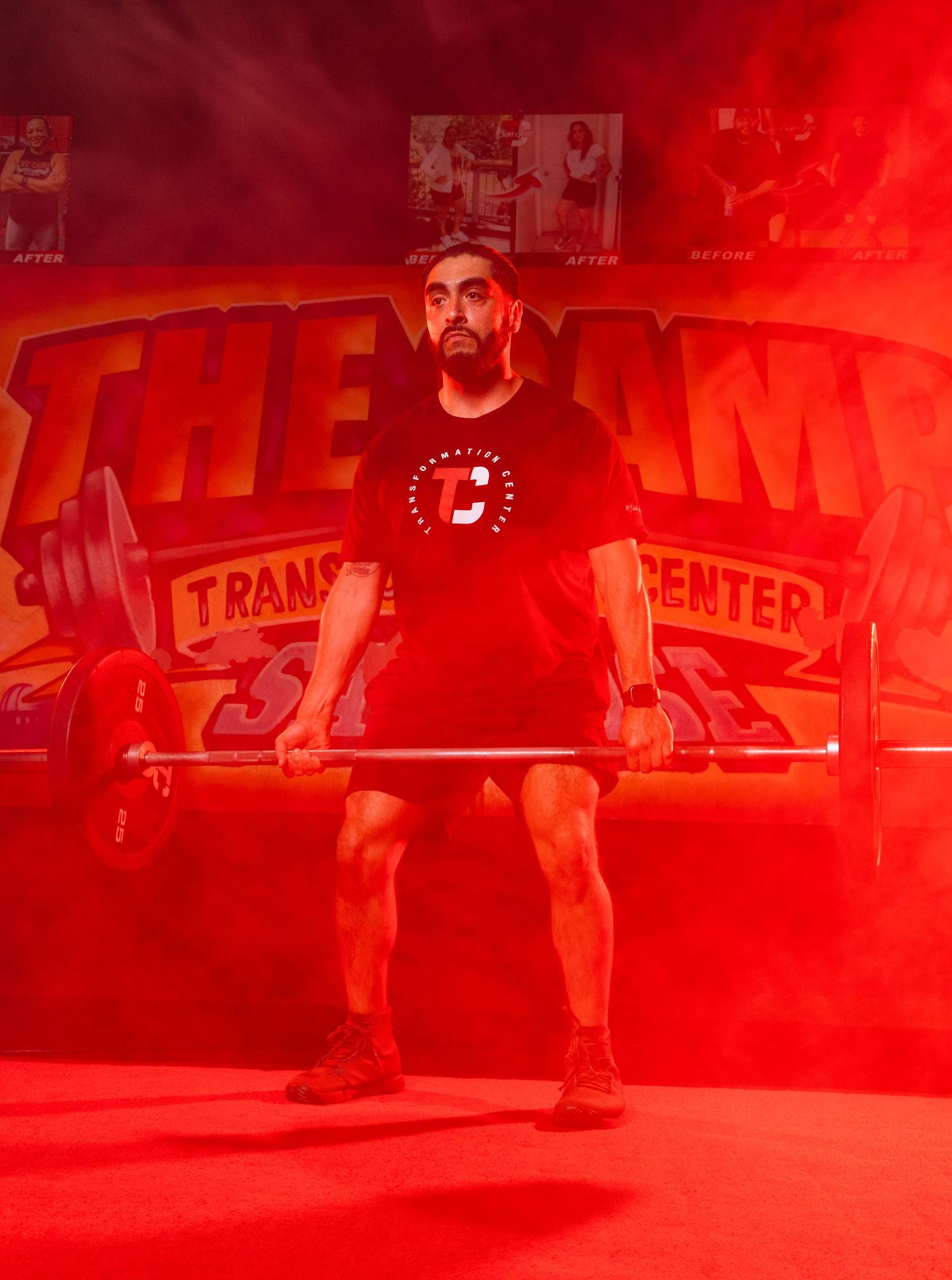 Weightlifter performing deadlift exercise in red-lit gym with barbell and weight plates.