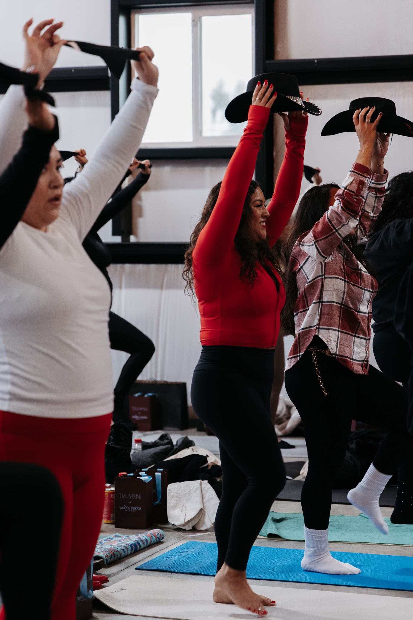 People participating in a group fitness class wearing red and black activewear.