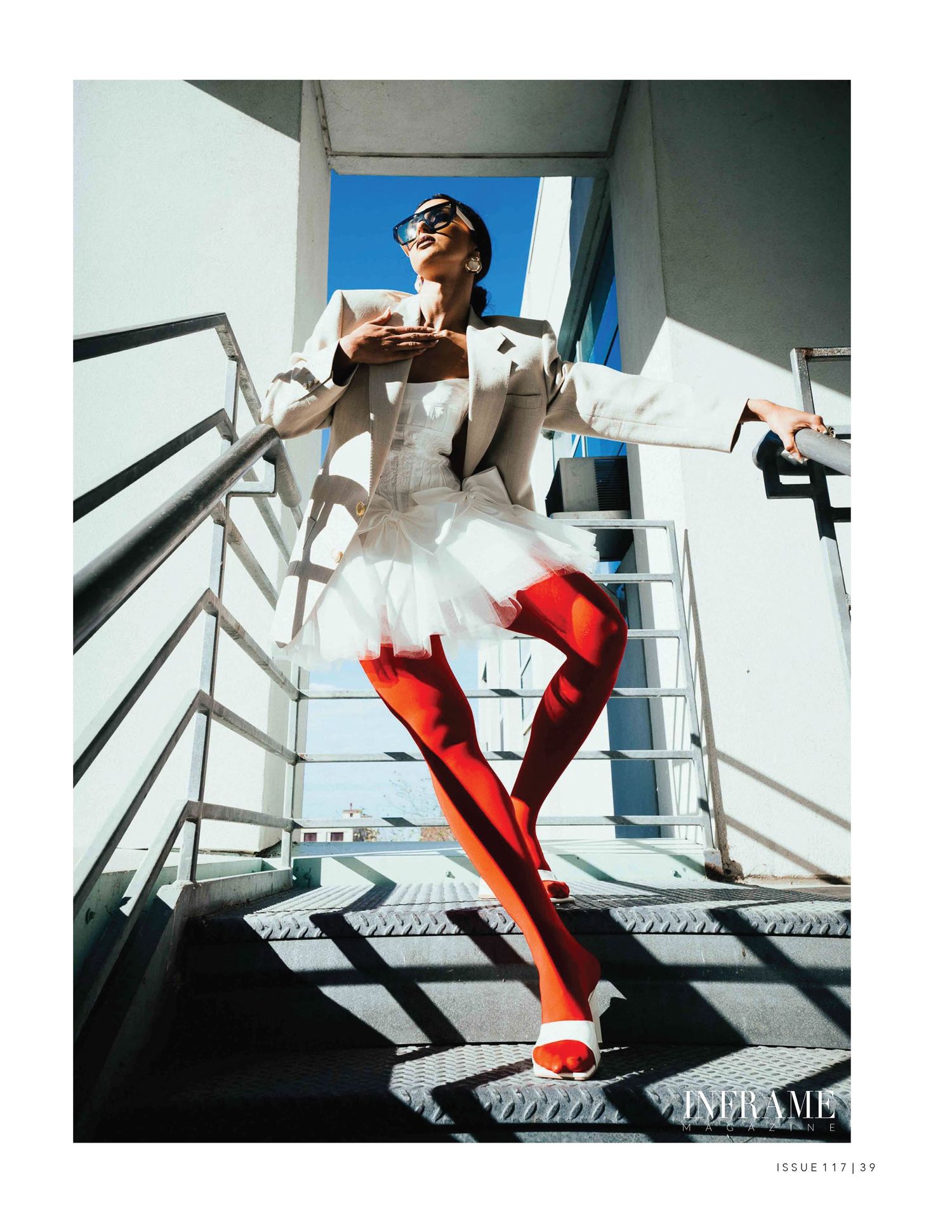 Abstract architectural fashion shoot with model in red boots against geometric white surfaces.