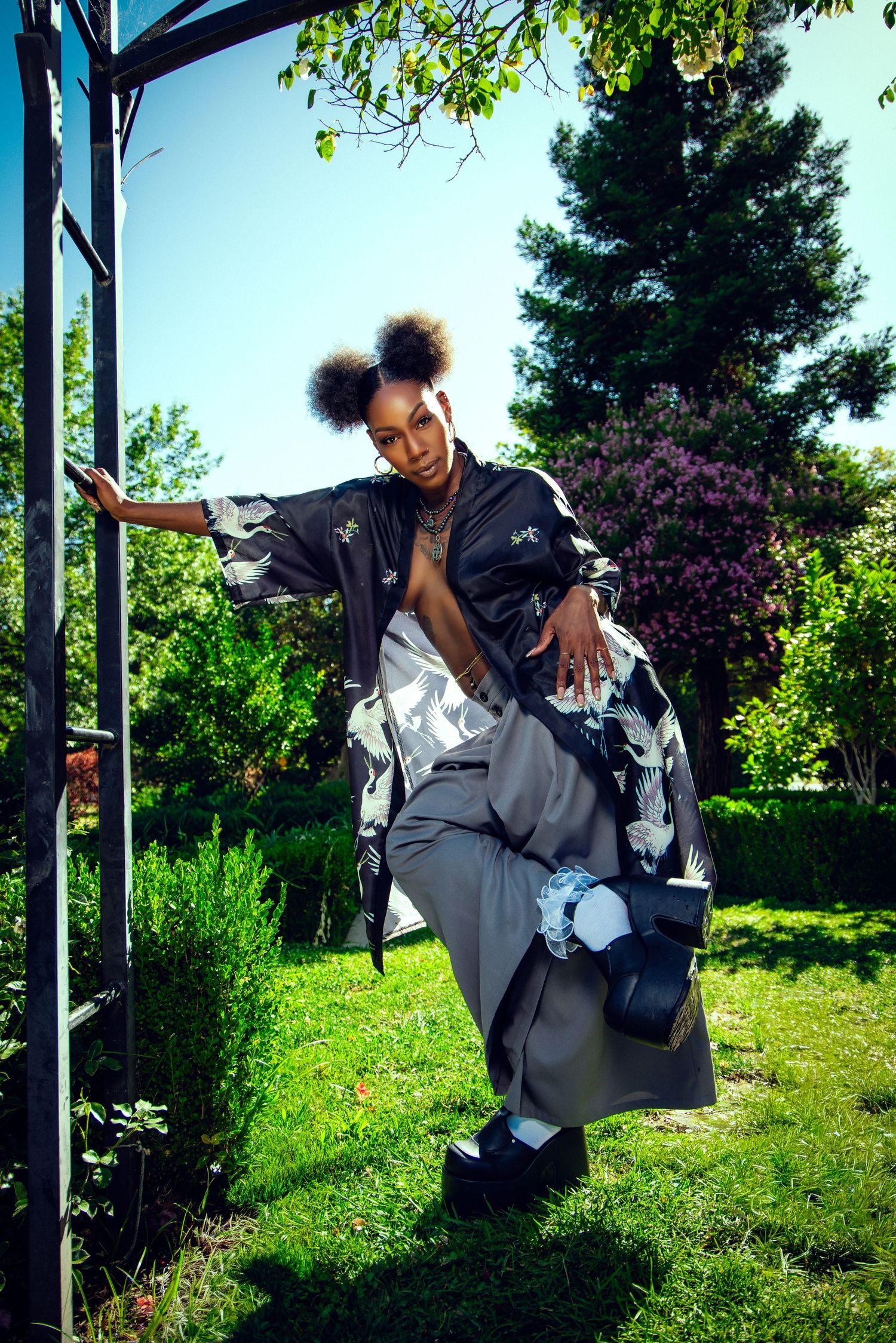 A person performs parkour moves across multiple frames on a sunny day with lush green foliage in the background.