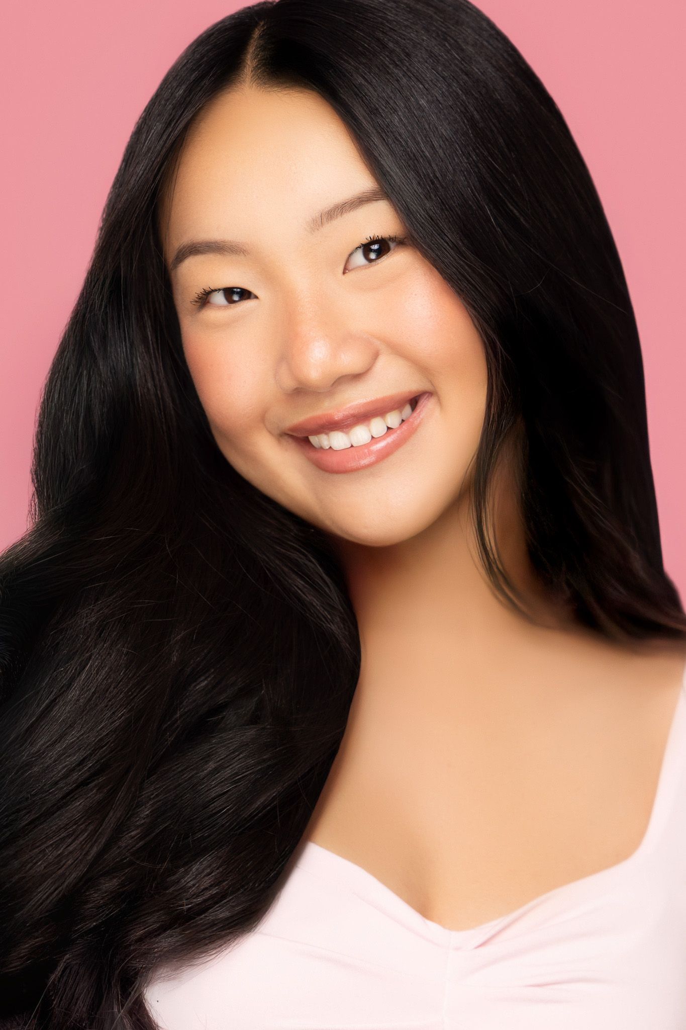Candid portrait series showing natural expressions against soft pink backdrop.
