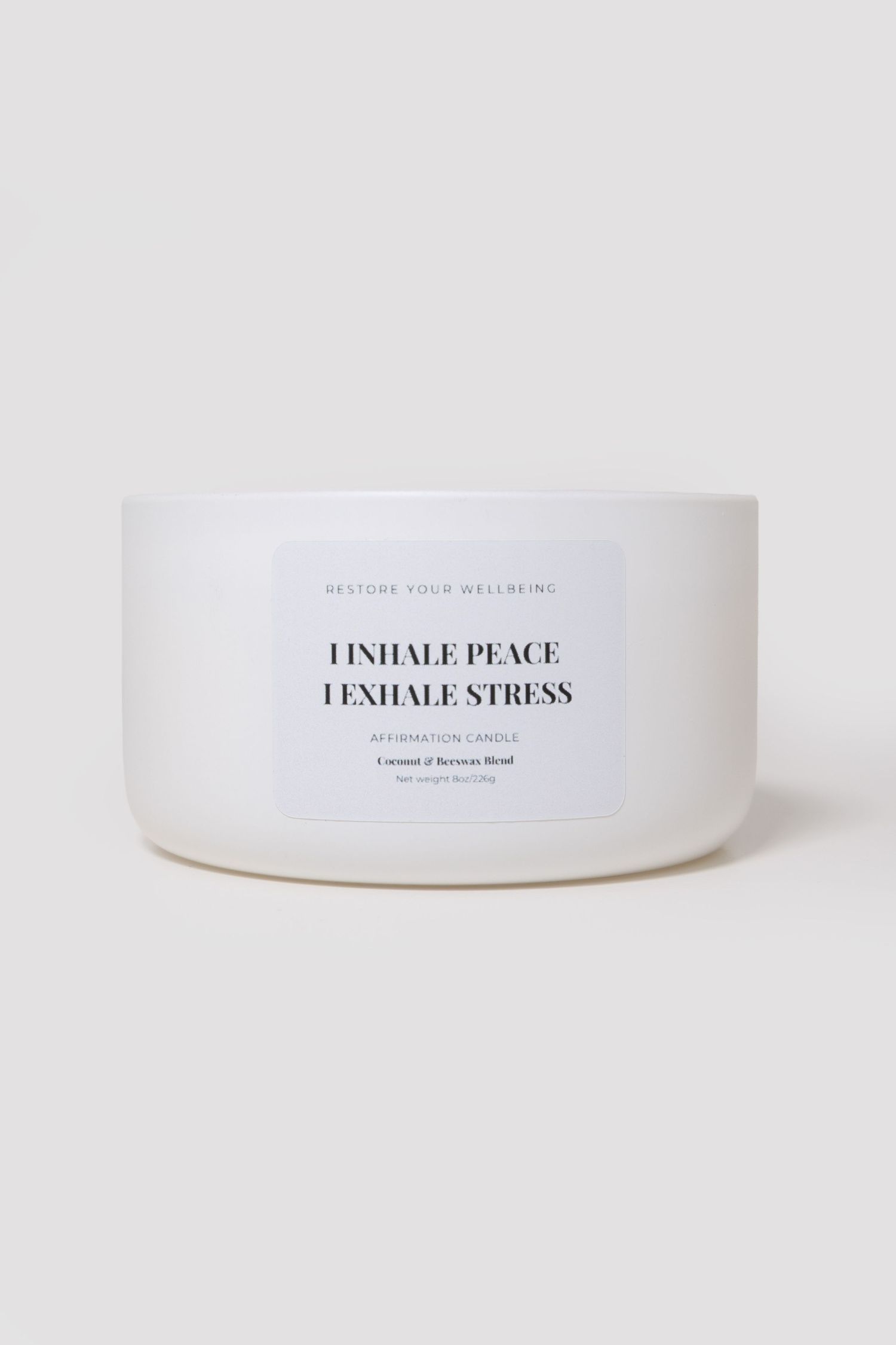 White affirmation candle with coconut and beeswax blend, labeled I Inhale Peace I Exhale Stress.