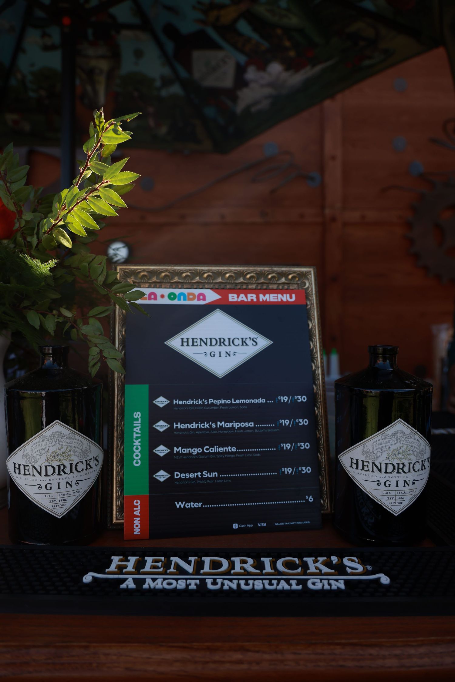 Hendrick's Gin branded display showing menu items and promotional materials on wooden surface.