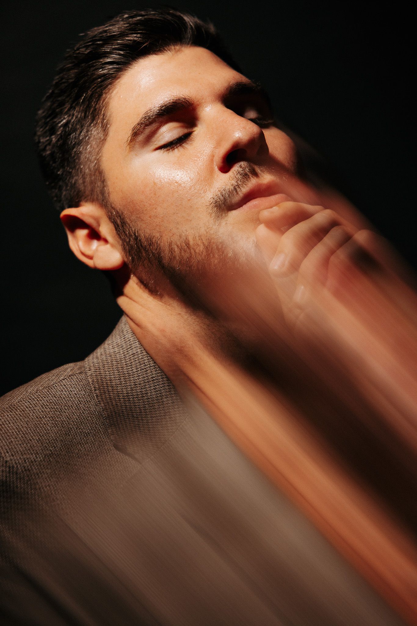 Series of profile portraits in dark moody lighting showing dramatic rays of light falling across the face and neck.
