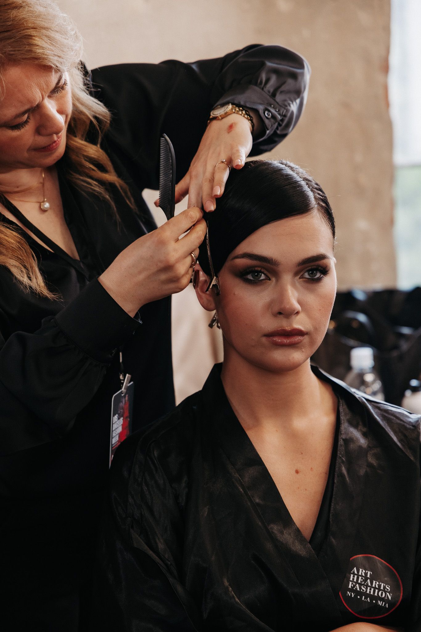 Behind the scenes makeup preparation showing professional styling process with black uniform.