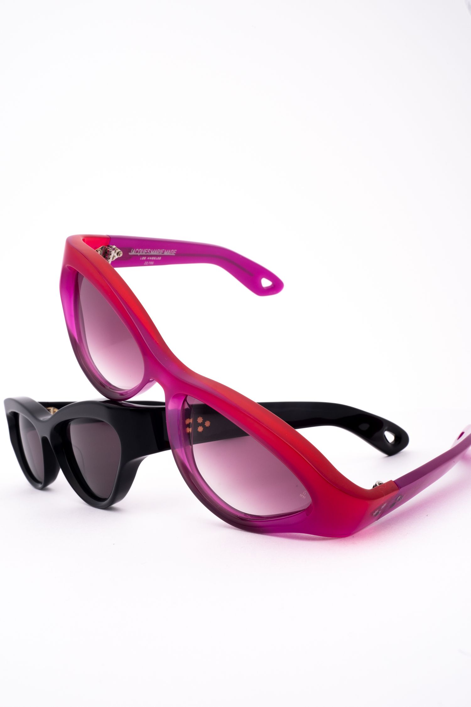 Stylish sunglasses with pink and black gradient frames shown from different angles against a white background.