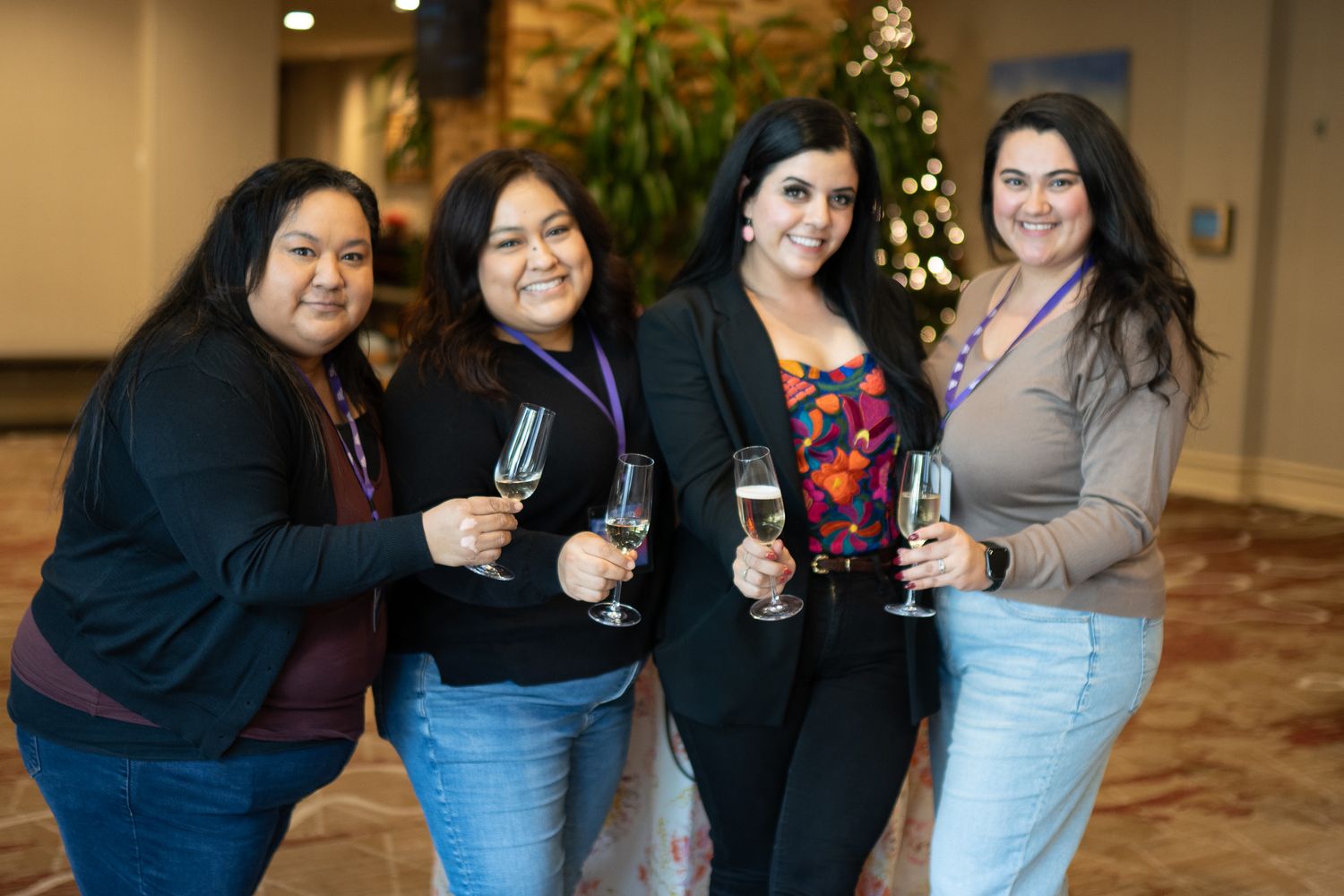A group poses with wine glasses during a social gathering in an elegant indoor setting.