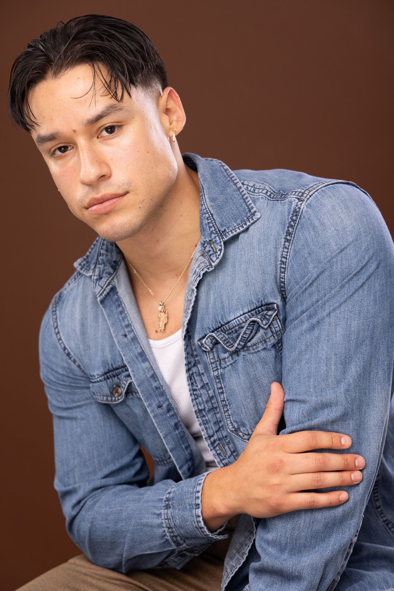 Portrait series of someone wearing a denim jacket against a brown backdrop.