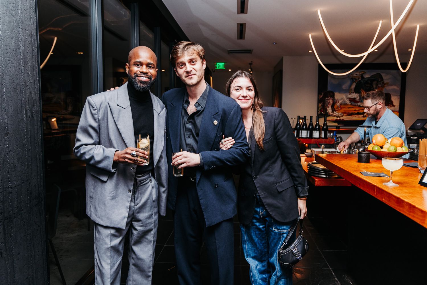 People mingling and networking at a dimly lit bar or lounge space.