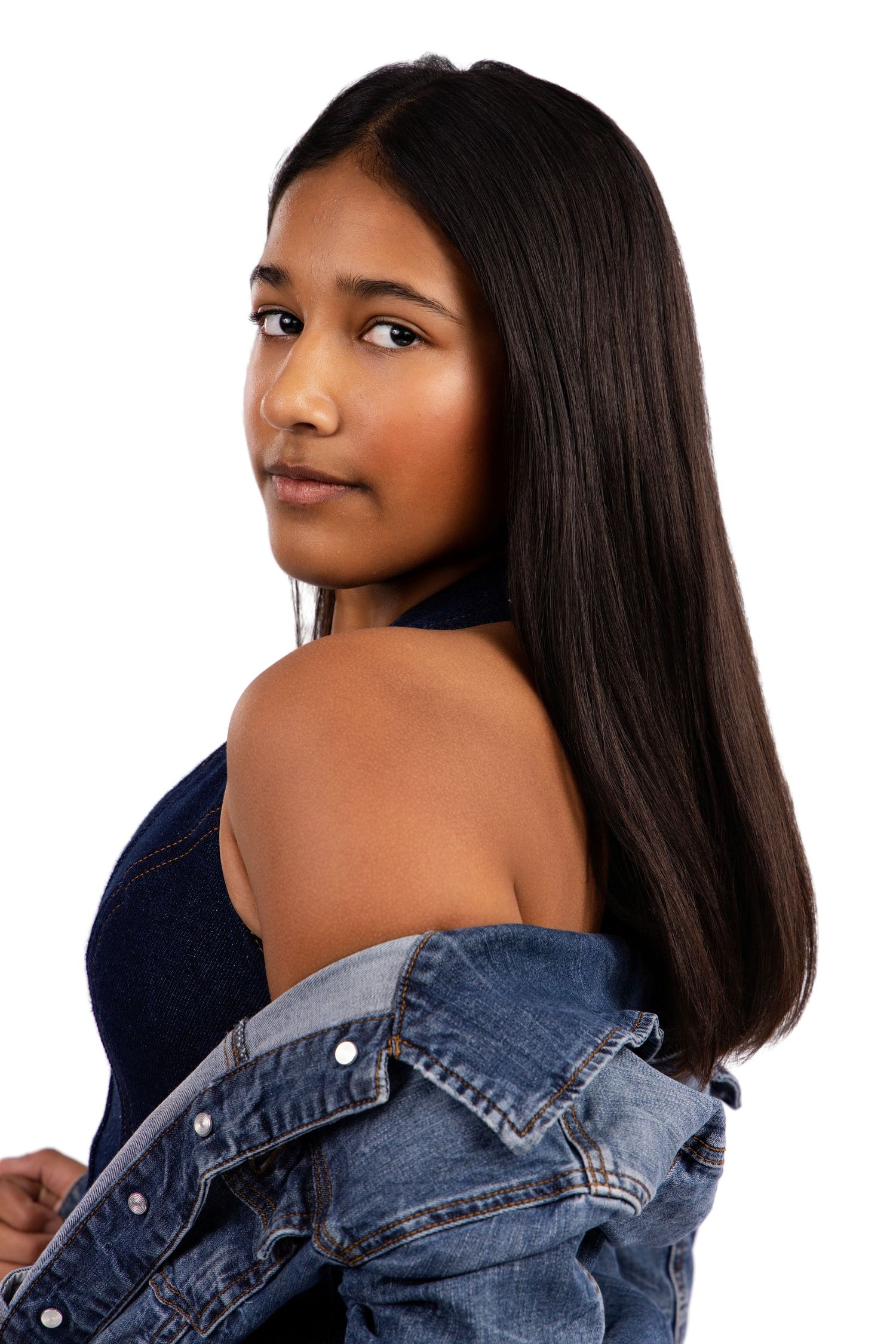 Person in denim jacket poses confidently in series of studio portraits against white backdrop.