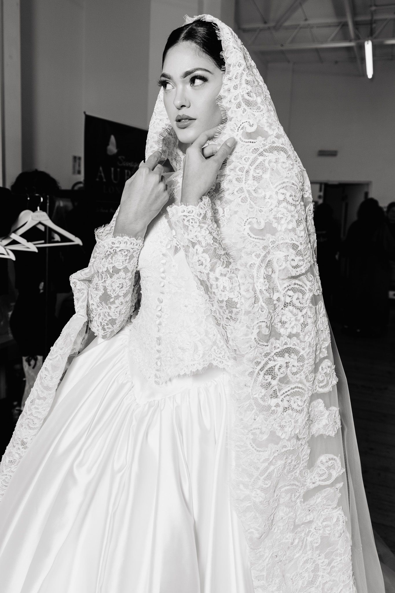 Close-up of intricate lace wedding veil and white gown details.