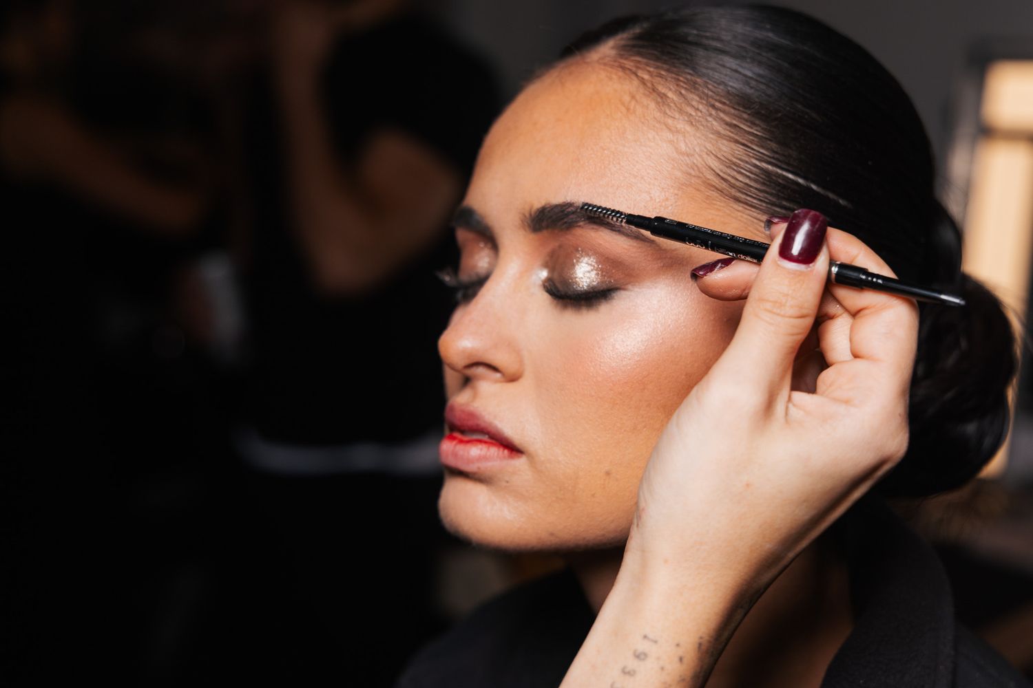 Close-up shots of professional makeup application focusing on eye makeup and mascara.