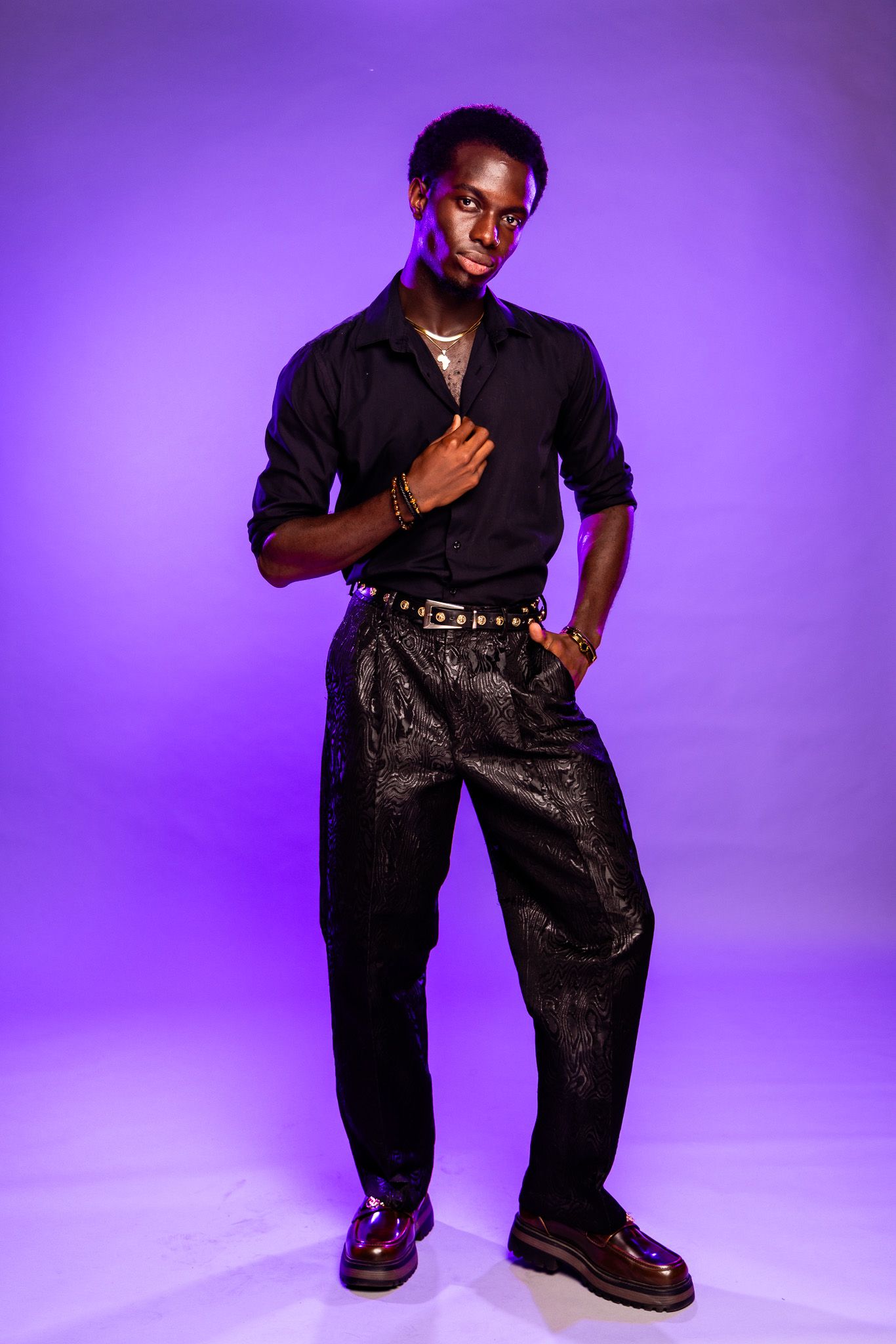 Model in black outfit strikes dynamic poses against purple backdrop in fashion photoshoot series.