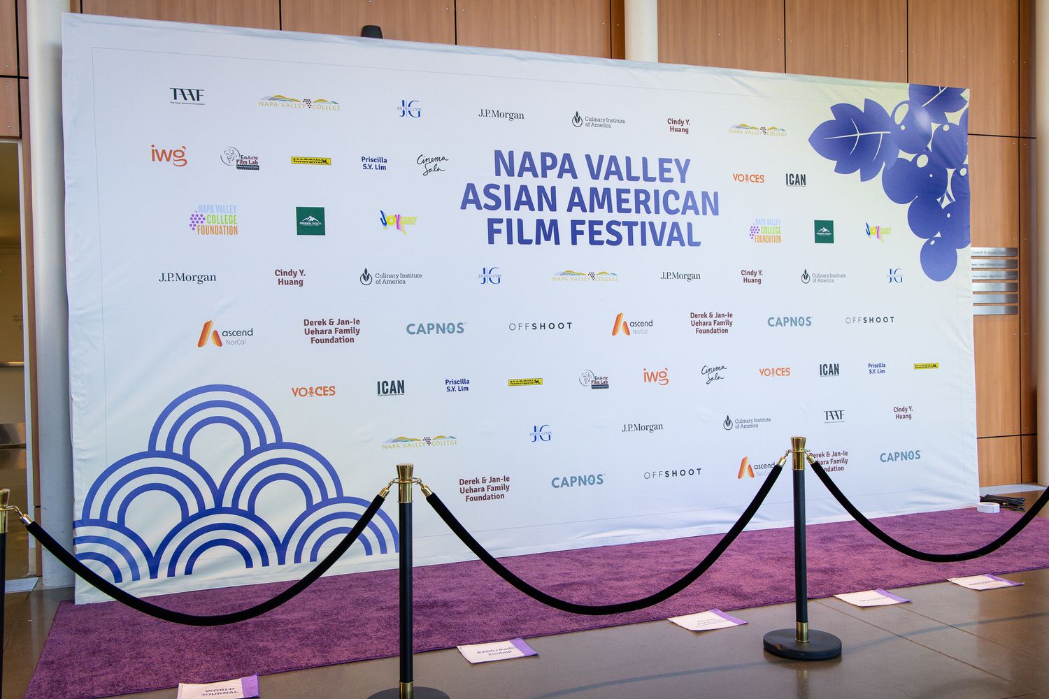 Step and repeat backdrop for Napa Valley Asian American Film Festival with sponsor logos and wave design.