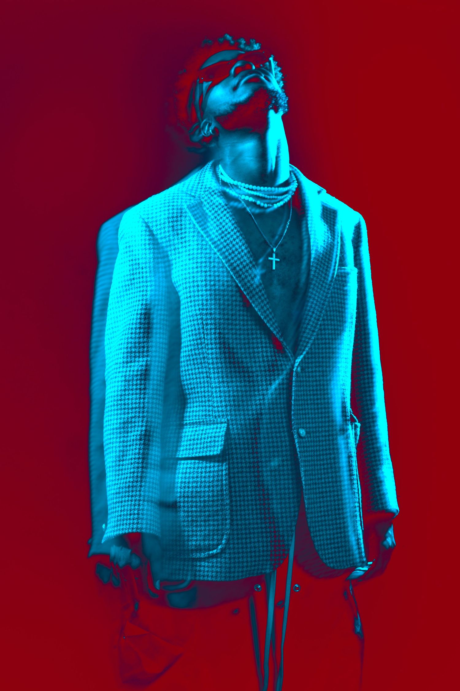 A stylized fashion photograph shows a textured blazer jacket in dramatic neon blue lighting against a red background.