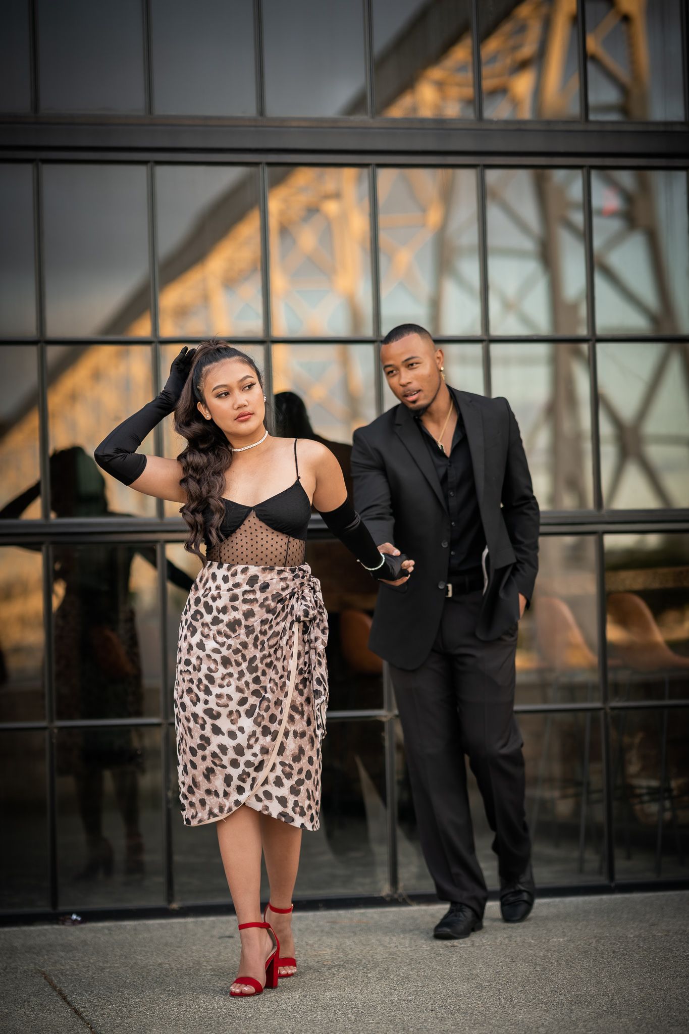 A couple poses for a series of romantic dance-inspired photos on a bridge at sunset.