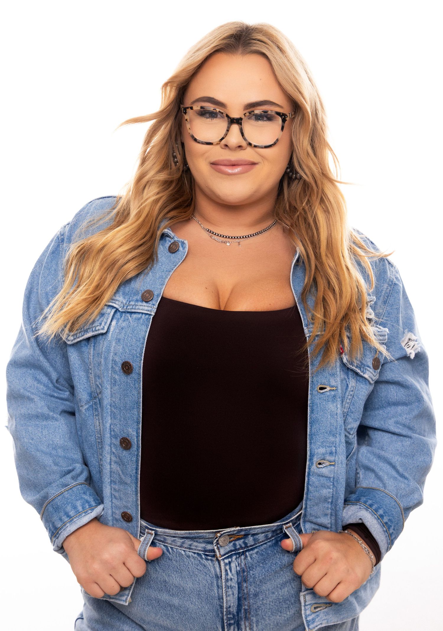 Blonde woman wearing black top and denim jacket poses in four different casual stances against white background.