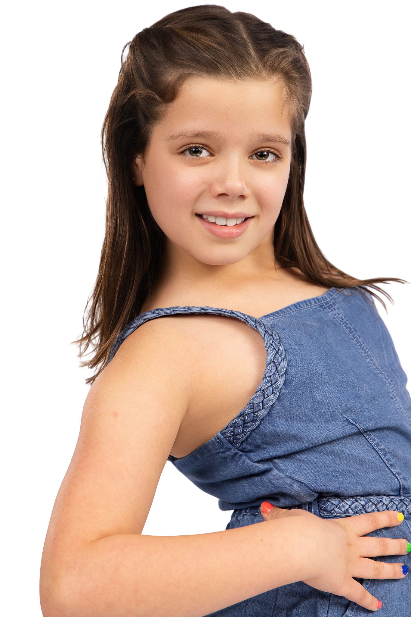 Young person wearing a blue sleeveless top with braided detail poses against white background.