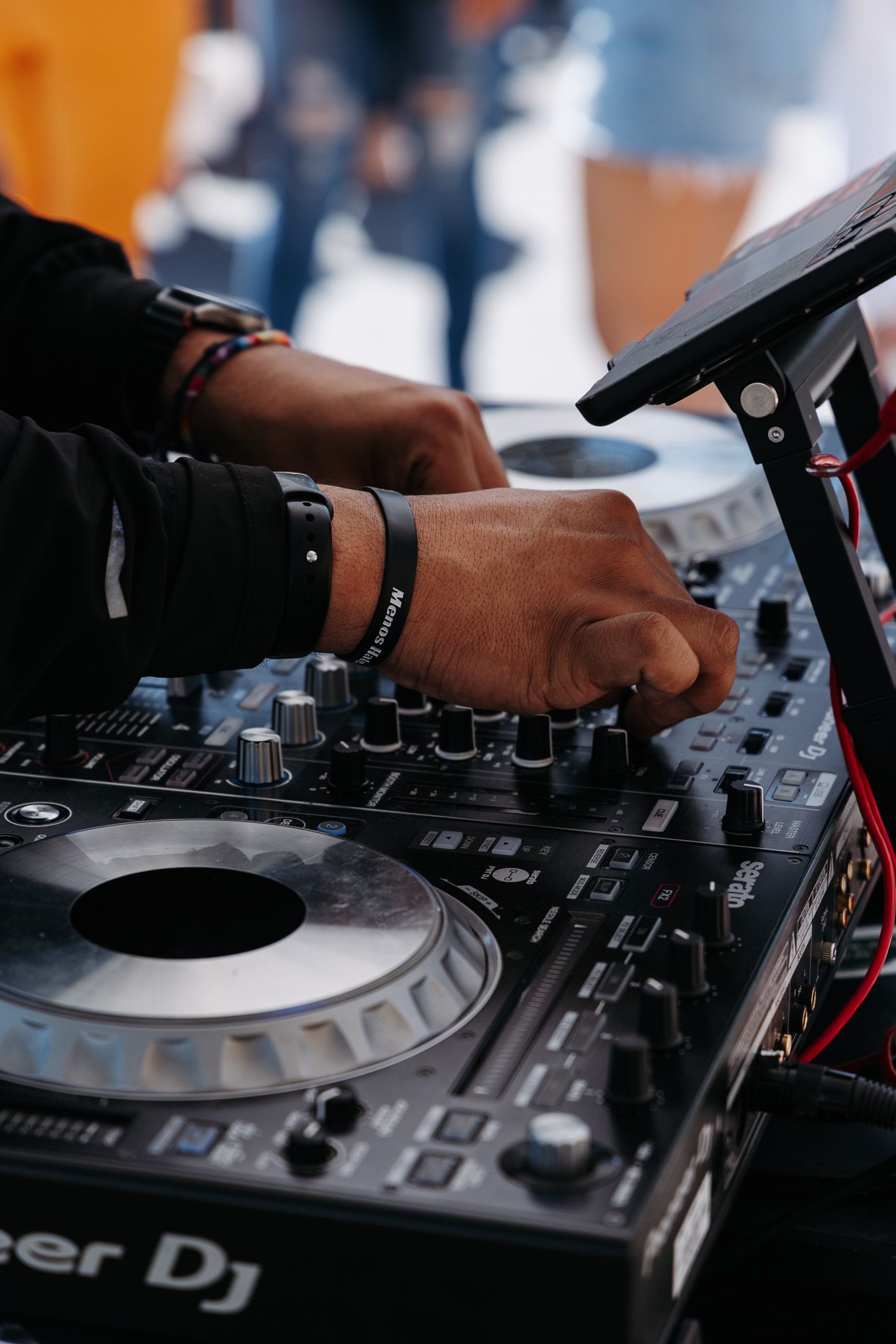 DJ hands adjusting controls on a professional mixing deck during a performance.