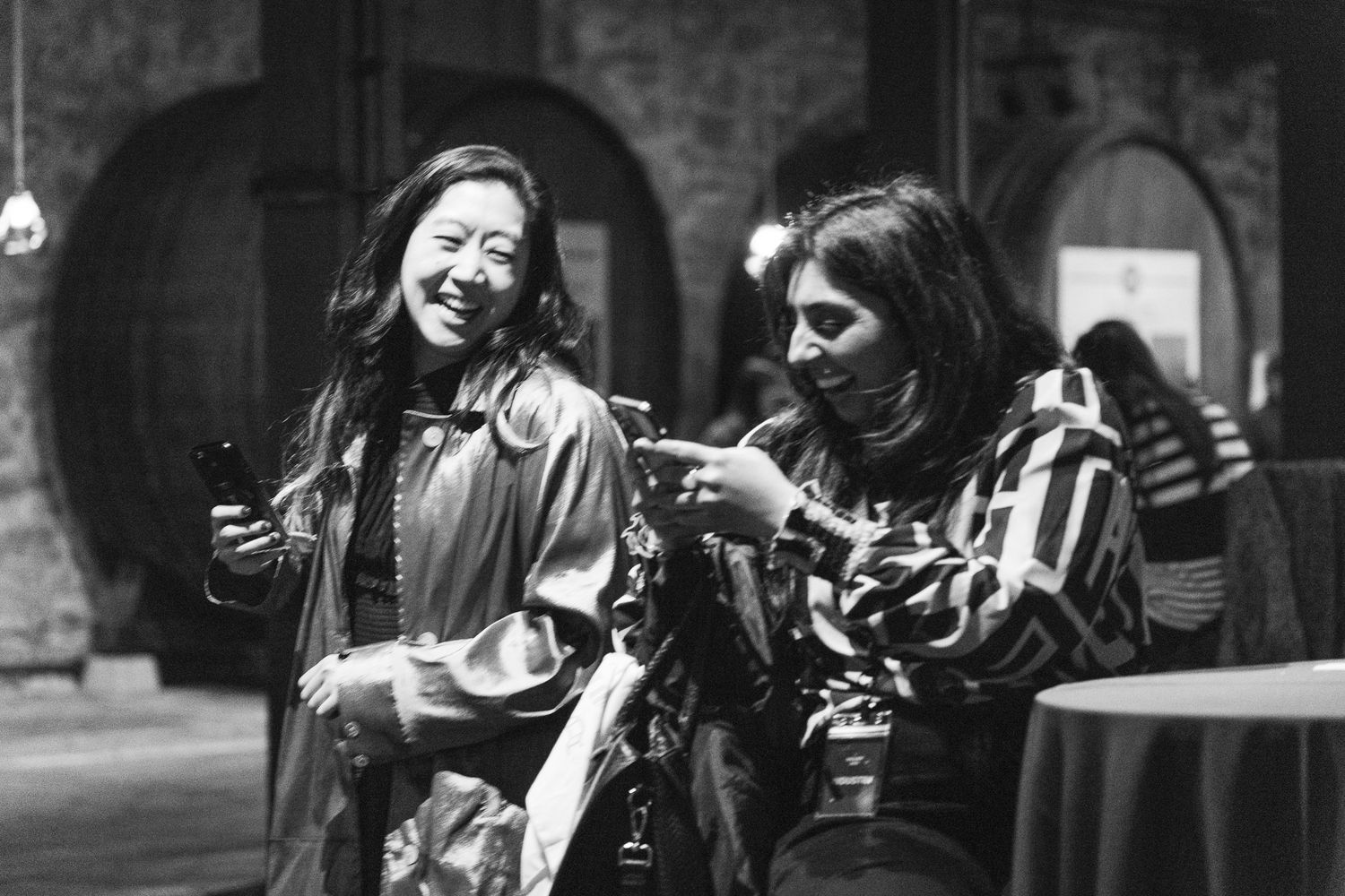 Two people share a joyful moment while laughing together in black and white photography.