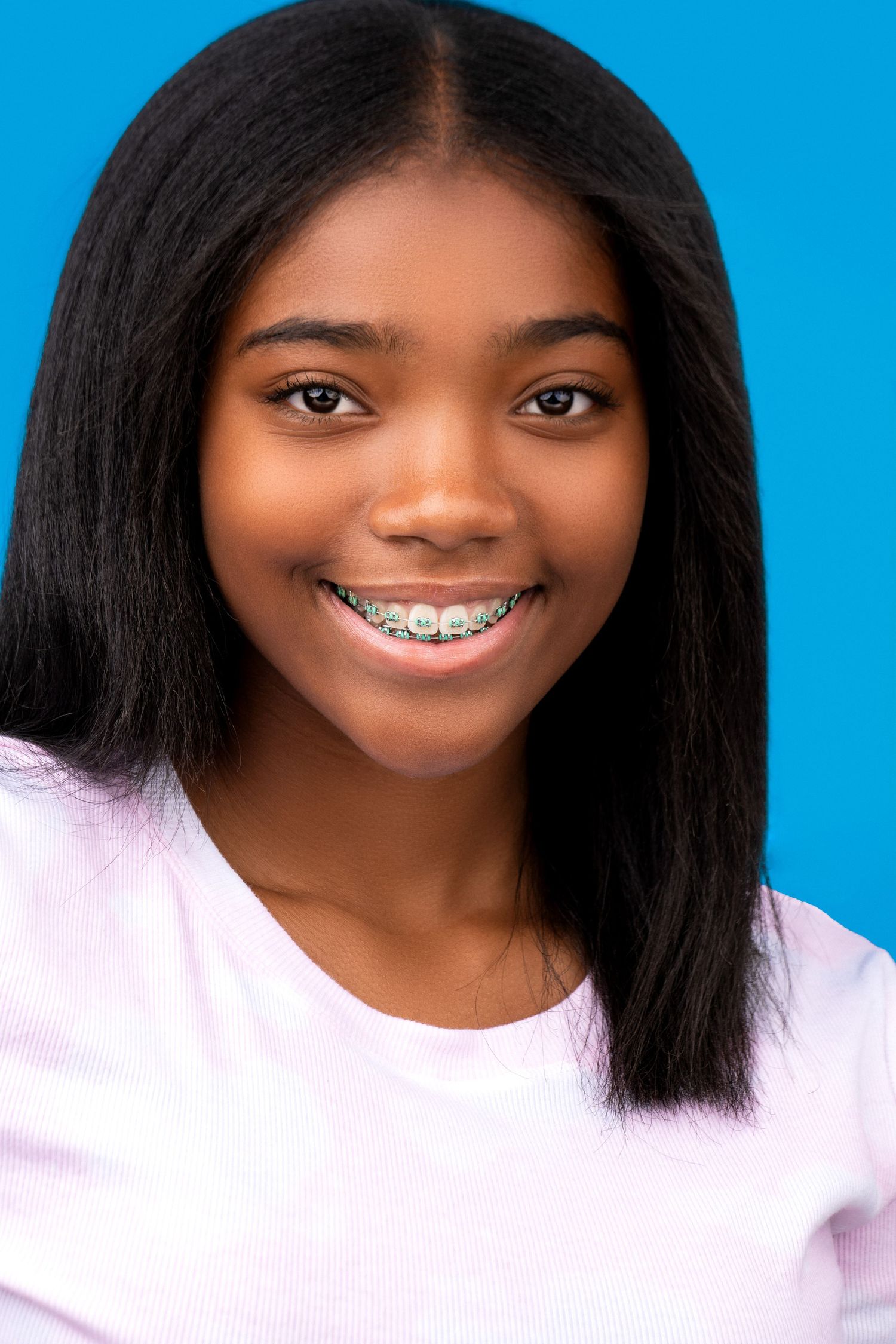 Composite photo sequence of bright smiles against blue background showing different angles and expressions.