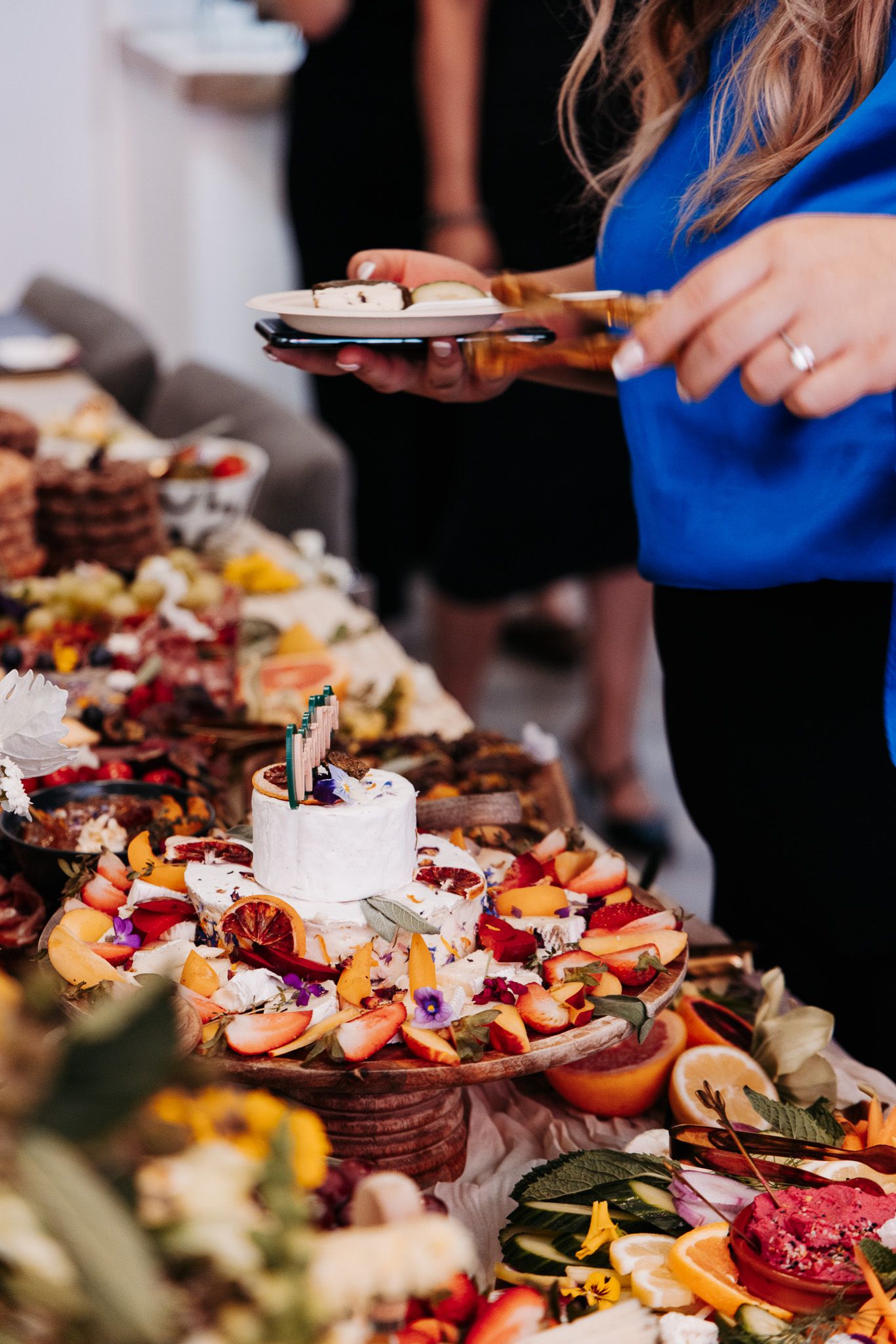 Elegant charcuterie board spread with meats, cheeses, fruits and breads served at a catered event.