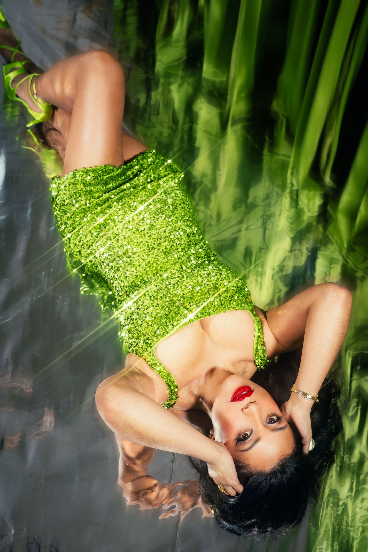 A sequence of artistic portraits in green lighting showing a model reclining against a bamboo backdrop.
