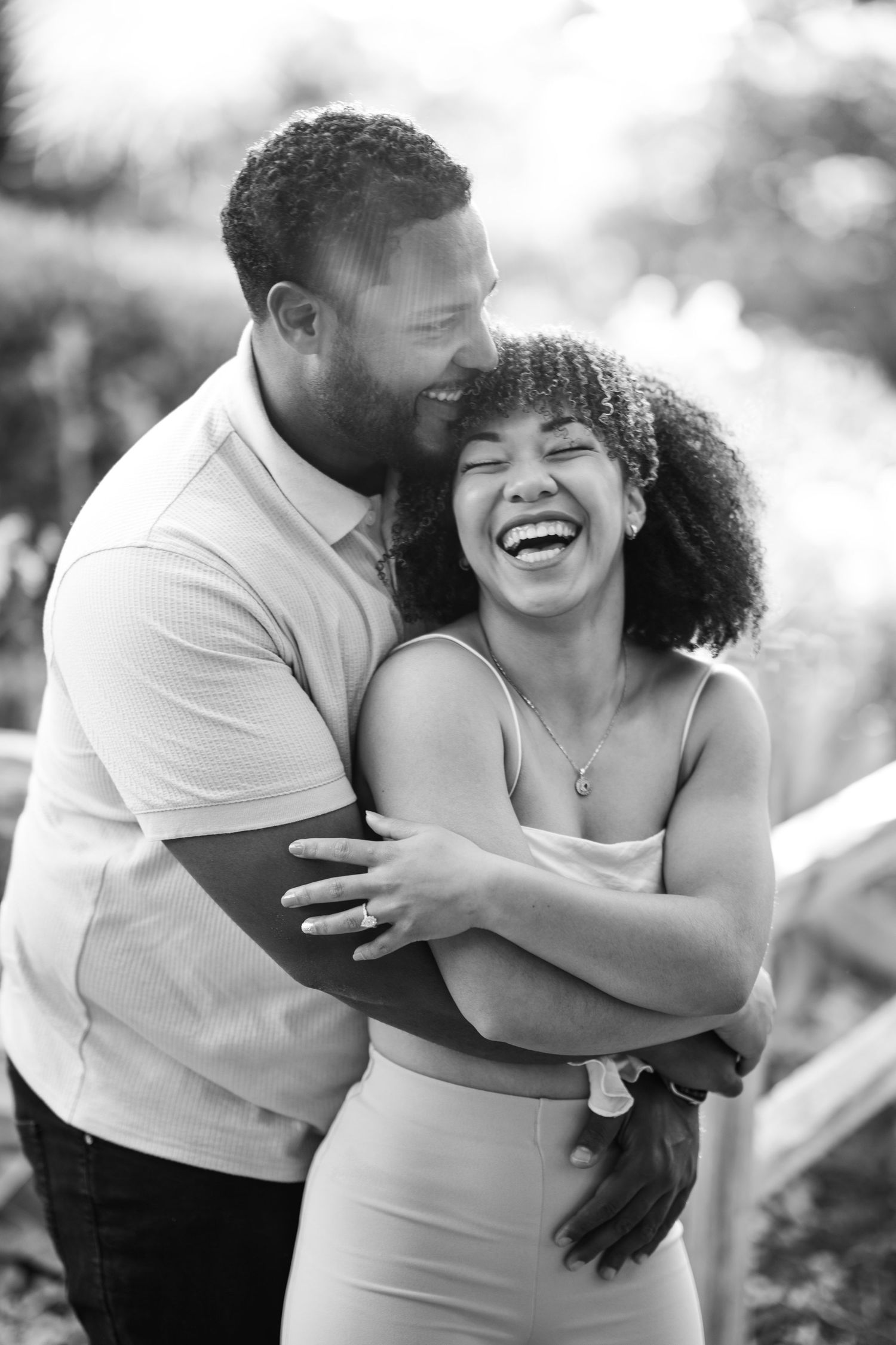 A joyful couple shares intimate laughing moments together in a series of black and white outdoor photos.