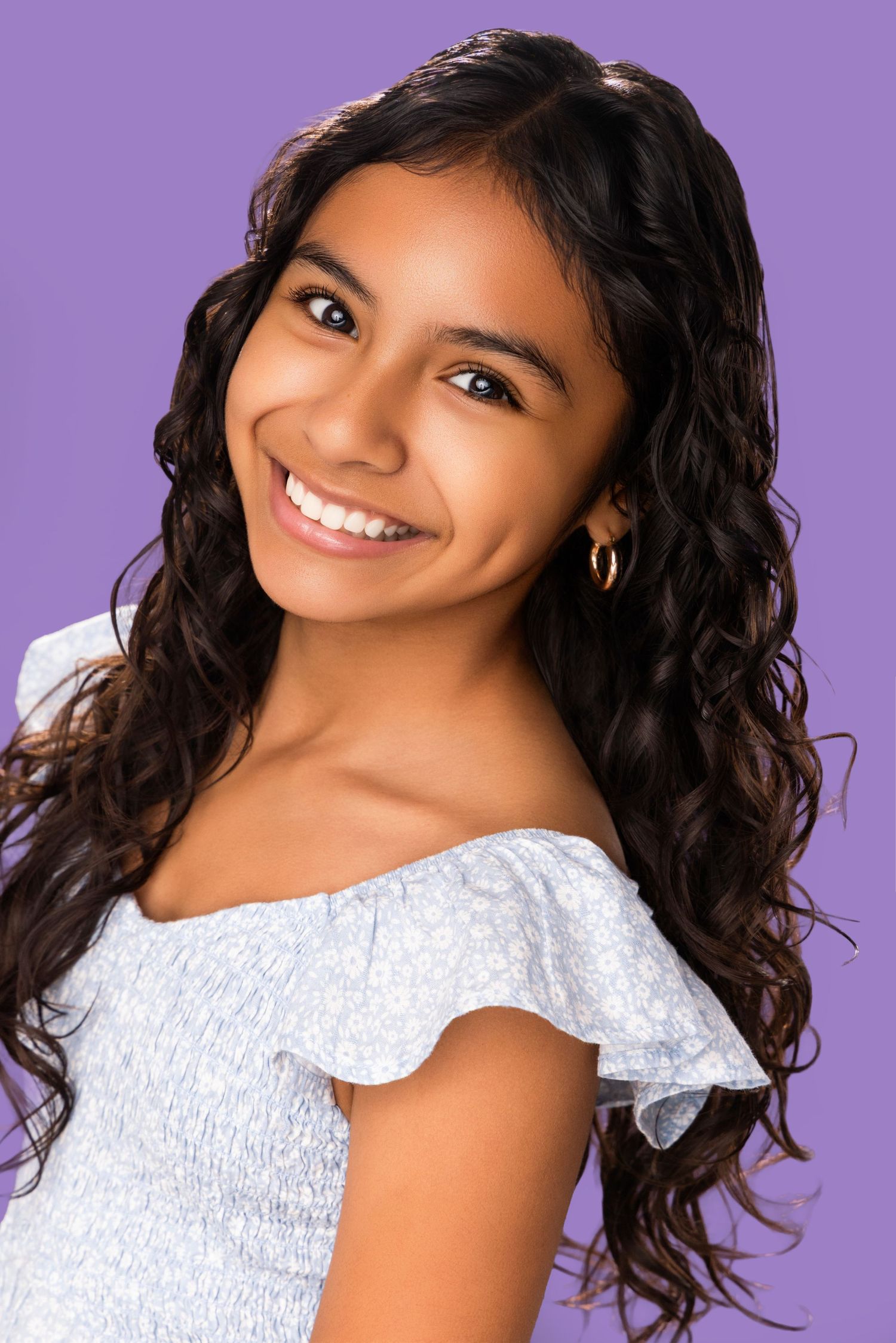 Portrait series against purple background showing curly dark hair and white lace top in various poses.