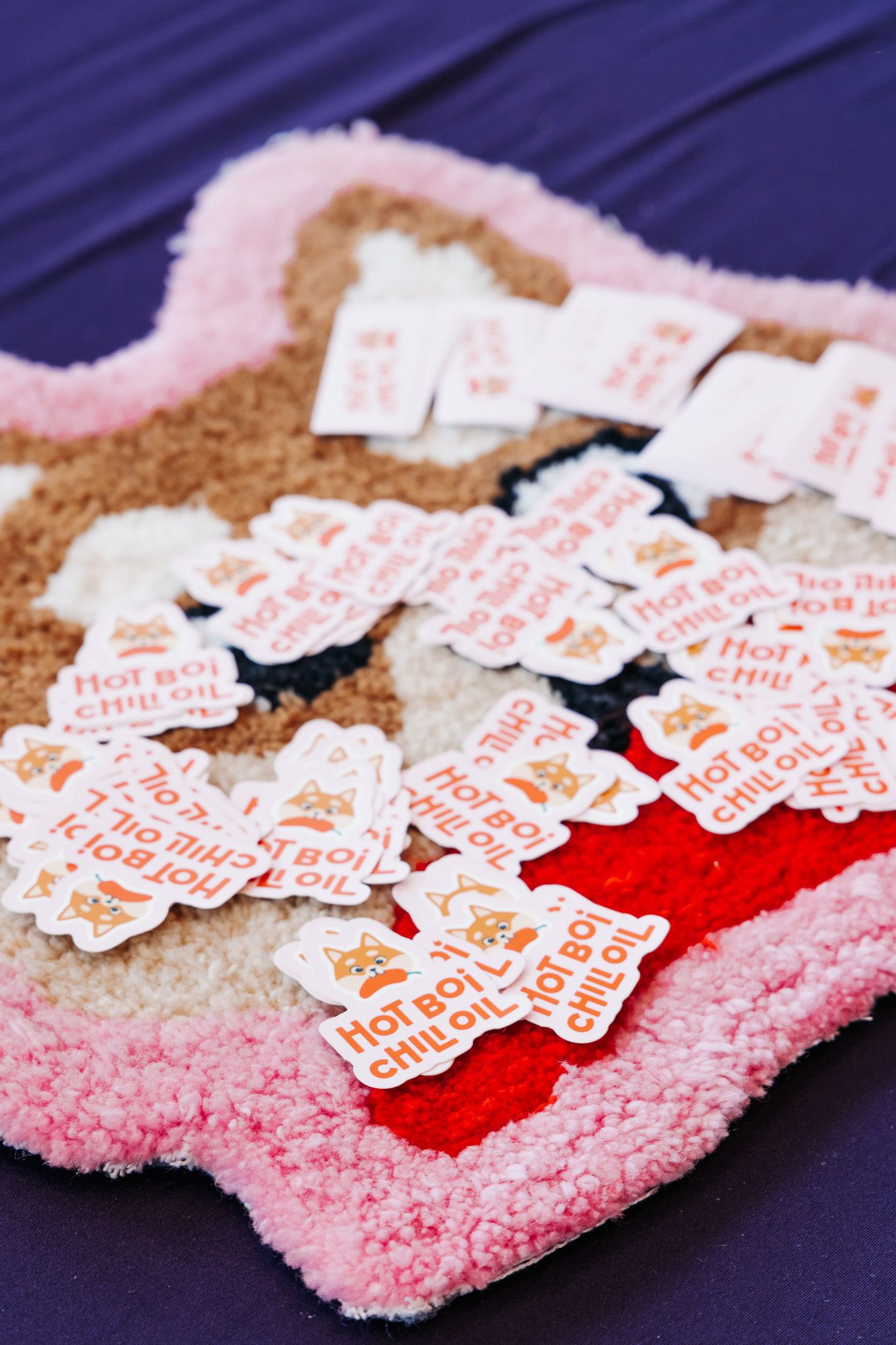 Pink fuzzy socks with scattered red and white stickers or tags arranged in a row on dark background.