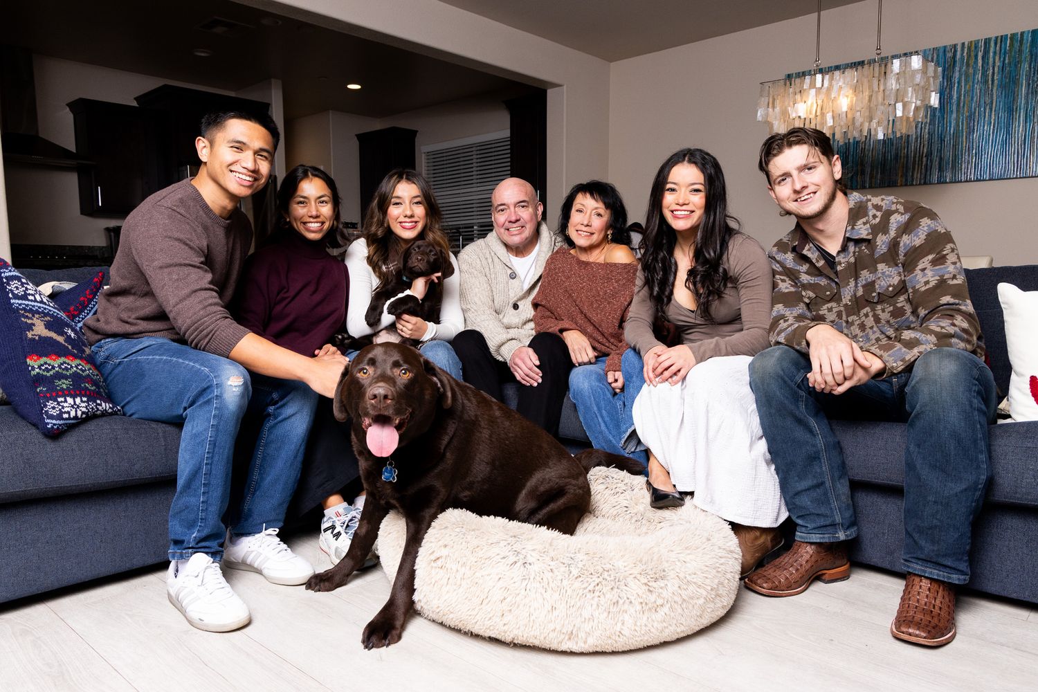 Group of friends lounging and relaxing together on a cozy sectional sofa in a living room.