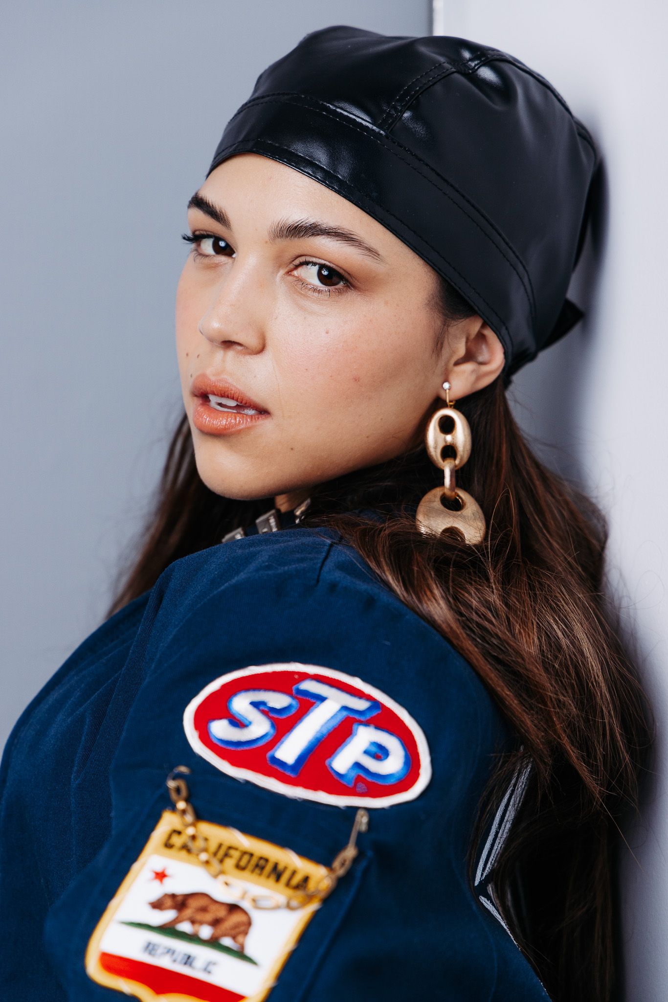 Close-up profile shots showing vintage sports patches and accessories on dark blue jacket.
