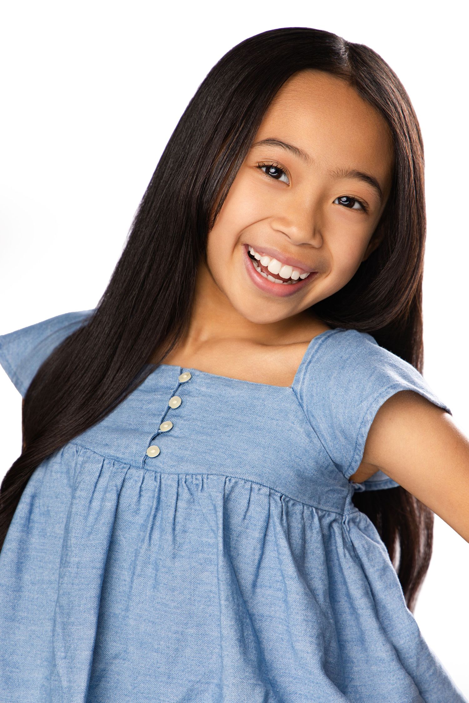 Collage of four photos showing a child in a light blue dress with button details against a white background.
