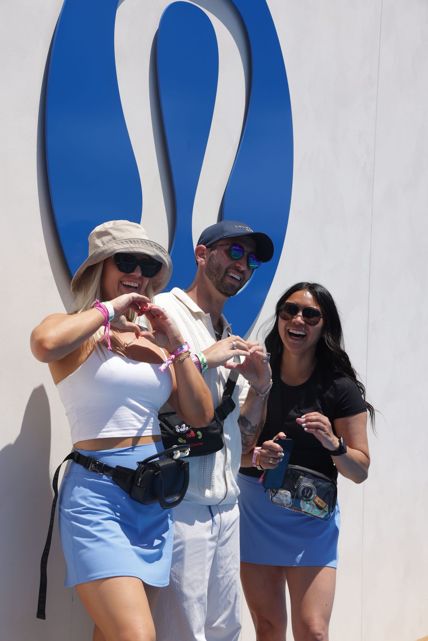 Group of friends laughing and posing in front of a white wall with blue decorative elements.